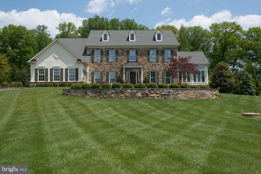 Impressive stone front colonial home with extensive hardscape; inground pool with independent hot tub; 2 additional BRs on lower level (no windows) and full bath; classic interior decor with many upgrades; master BR w/sitting area, 2 wlk-in closets, soaking tub & sep shower; exercise room; tray ceilings; gourmet kitchen with center work island, granite countertops, s/s appliances, and more.