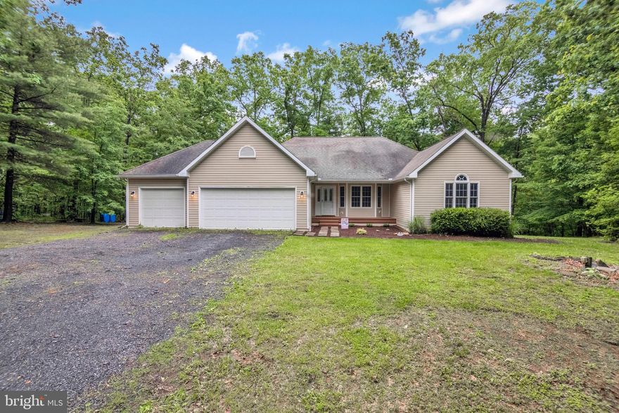 Welcome to 164 Wandering Lane, a stunning ranch-style retreat situated on approximately 6.5 acres just outside of Hedgesville. This picturesque property offers a serene escape, surrounded by mature trees, abundant wildlife, and a peaceful creek that enhances the natural charm of the estate. The exterior features a welcoming front porch framed by beautiful landscaping, while the back of the home boasts a spacious deck and a separate screened-in sitting area, perfect for relaxing or entertaining while taking in the views of the surrounding nature. Inside, the home opens to a bright and inviting foyer, recently updated with luxury vinyl plank flooring and fresh paint. To the left, a dedicated laundry room provides easy access to the sizable three-car garage! The kitchen is both functional and stylish, featuring new flooring, upgraded stainless steel appliances, ample cabinet storage, a double-sided sink, backsplash and cabinet lighting. Just off the kitchen, the living room offers a cozy and airy atmosphere with brand new carpeting, fresh paint, and two ceiling fans. Large windows border a beautiful stone gas fireplace, filling the space with natural light. Adjacent to the living area is the dining room, updated with new flooring, fresh paint, crown molding, and a modern light fixture. The dining space also offers direct access to the screened-in porch, making it ideal for indoor-outdoor living. Down the hall, two generously sized bedrooms share a large bathroom complete with a separate water closet for added privacy. The primary bedroom is a private haven with new carpeting, fresh paint, and direct access to the back deck. The en suite bath features tile flooring, a spacious closet, a jetted soaking tub, and a separate stand-up shower. The full basement presents endless possibilities with a bathroom rough-in already in place. Whether you envision a recreation room, home gym, or extended living area, this space is ready to suit your needs. A beautiful wood stove adds to the charm and warmth of the lower level. This exceptional property combines privacy and natural beauty with convenient access to both Hedgesville and Berkeley Springs. Don’t miss this unique opportunity—schedule your showing today.