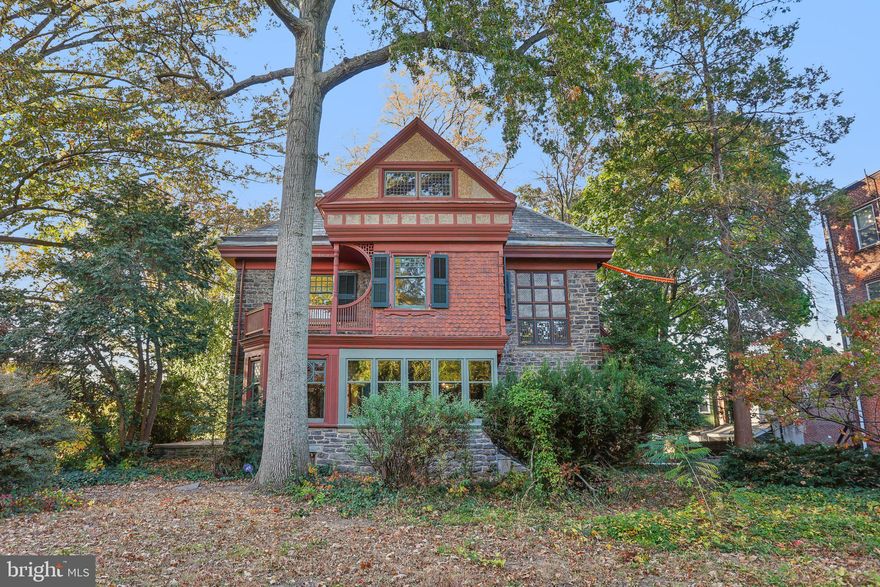 Welcome to 51 E. Penn Street, a remarkable 5-bedroom+, 2.5-bathroom residence nestled on a peaceful wooded lot in the heart of historic Germantown. Designed by the renowned architect George T. Pearson, this home beautifully combines Aesthetic and Victorian design, blending the best of both styles into a timeless architectural masterpiece, in a community characterized by a popular urban farm-stand and active neighborhood associations. Within walking distance of Germantown Avenue and two train stations, central Philadelphia is just a 20-minute drive away. 
Stepping inside, you are greeted by the brilliance of original stained-glass windows, filling the interior with vibrant colors and light. The grand entryway, with its stunning stained-glass panel above the front door, showcases Pearson’s signature attention to detail. The interior features intricate millwork, handcrafted wood detailing and dentil crown molding, testaments to the historic craftsmanship that defines this home. The living room's magnificent fireplace stands as a testament to the home’s unique character, with its intricately detailed mantel adorned with one-of-a-kind tiles, sunburst-themed wood carvings, and a quaint storage niche—a true conversation piece.
The large dining room is bathed in light by a floor to ceiling window, classic wall sconces and a custom beautiful built-in cabinet featuring remarkable craftsmanship and attention to detail. Featuring decorative leaded glass panels with a classic geometric pattern, the piece highlights a Victorian and Aesthetic influence that define 51 E. Penn Street. Brass hardware complements the dark wood finish, adding a warm, historic charm.
One of the most unique features is the coffered ceiling with a starry night design located on the second-floor landing. This whimsical, artistic detail adds a touch of wonder to the space, offering a glimpse into the creativity of the original design. The expansive windows throughout the home provide picturesque views of the lush surroundings, allowing natural light to pour into the living areas, enhancing the serene connection between the indoors and the peaceful 0.68-acre lot outside.
The home also boasts decorative leaded glass, brass hardware, and custom-built shelving in the dining room and library, providing both beauty and function, and underscoring the home’s elegant design.
Though the home’s architectural features are well-preserved, there is ample opportunity for modernization in the kitchen and bathrooms—including 2 full and 1 half bathroom—allowing you to create spaces that reflect your personal style while maintaining the historic charm of the property. Recent roof and gutter work by Kurtz Construction plus a new HVAC and hot water system ensures that the property’s exterior and many of the mechanicals are in excellent condition, allowing you to focus on making the interior your own.
Complete with ample private off-street parking, the surprisingly large lot offers a private outdoor oasis, ideal for gardening, entertaining, or simply enjoying the tranquility of the surrounding greenery—an uncommon find in the city.
A true ‘unicorn’ of a property full of hidden treasure, 51 E. Penn Street is a rare opportunity to own a piece of Philadelphia’s architectural history. This home merges timeless beauty with modern-day potential, offering the perfect canvas to write your own chapter in its storied legacy. Schedule your private tour today to experience the historic elegance and countless possibilities that await at this extraordinary residence.