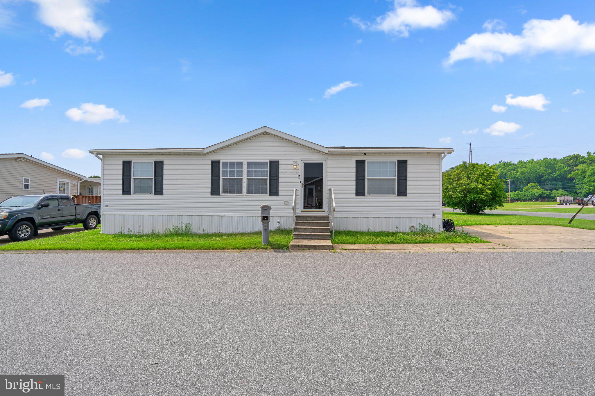 Set in quiet community of Peppermint Woods, this 3 bedroom and 2 full bath double mobile home is ready for you.Space and light create a stunning atmosphere in this ranch-style home featuring a vaulted ceiling, a living room with a lighted ceiling fan, an open dining room adjacent to the kitchen with access to the sunporch, and a fully appointed kitchen.The cook's kitchen boasts a vaulted ceiling with a skylight, ample counter space, raised panel and glass front wood cabinetry, crisp white appliances, and a breakfast bar backing to the living room.Additional: owner's suite with a walk-in closet and private bath, a laundry room with a walkout to the side, a sunporch with a second walkout, a community playground, and a 2-car parking pad