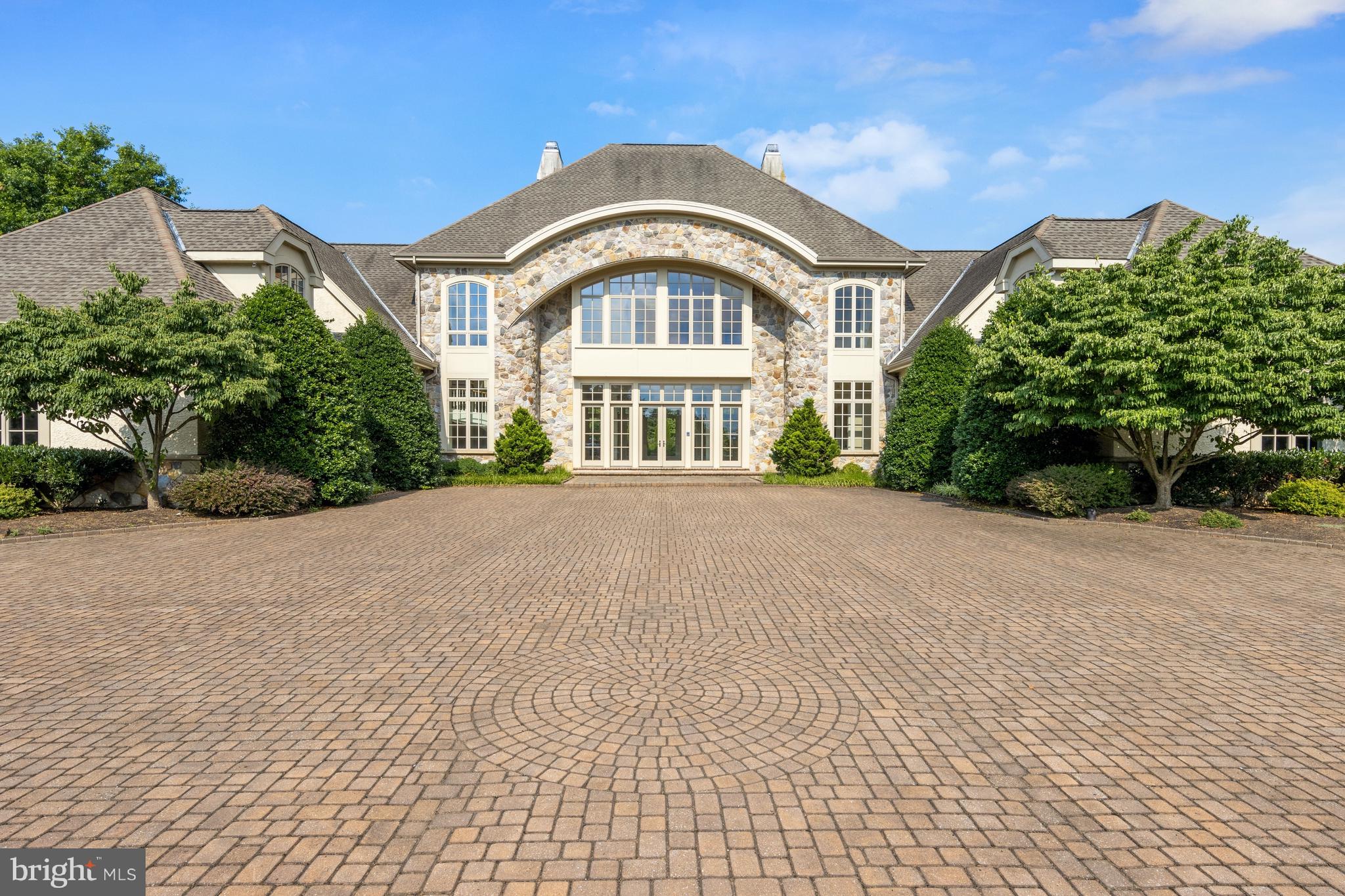 Visit this home virtually: http://www.vht.com/434082464/IDXS -PROPERTY BEING SOLD "AS-IS". This stunning contemporary home is set on a 4.5 acre lot set back off of the road. Immediately notice the finely manicured landscaping as you pull into the courtyard driveway with plenty of parking for guests. Enter through the large front door into the open 2-story foyer and great room. Flooded with natural light through walls of windows, this stunning space is wide open. Soaring coffered ceilings and custom millwork offer a grand impression. The great room features gas fireplace, built-in cabinetry, French doors to the rear patio, wood floors and includes a dining area as well. The chefs kitchen features custom cabinetry, high-end appliances, center island with seating and separate pantry. A wet bar with additional cabinetry extends off from the kitchen into the dining/great room. Continue through to the open family room with gas fireplace and patio access. The main floor master suite is large and luxurious. The bedroom offers high vaulted ceiling, gas fireplace, built-in cabinetry, wet bar with fridge, 2 large walk-in closets with shelving systems and patio access. The master bath includes walk-in shower, jetted soaking tub and double vanities. The first floor also features a laundry room and powder room. Head up either the formal or informal staircase to find 5 guest suites. Two of the mirrored guest suites serve as optional master suites with sitting rooms, 5-piece baths and walk-in closets. Unfinished attic space abounds for storage or endless possibilities. The finished lower has full kitchen, game room, exercise room, full bath and temperature controlled wine room. The outdoor oasis includes heated pool, spa and water feature, large stone patio with built-in bar/BBQ and pool house. Perfect for car enthusiasts - there are 2 attached 3-car garages on either side of the house as well as a detached 3-car garage with unfinished space above. This house is an entertainers dream! All of this while still being close to downtown Wilmington, Philadelphia and all major roads.