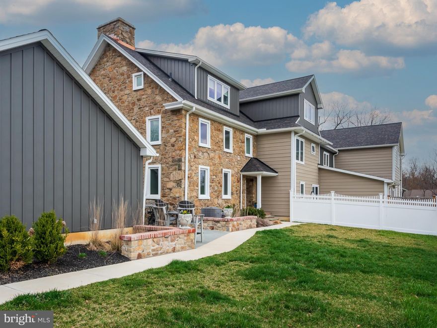 Step into a masterfully designed 2401 sq ft. home that seamlessly blends old world character with contemporary convenience.  This exceptional 3 BD 2/2 Bath end-unit cottage completed in 2023, is part of an exclusive five-home restoration, built within the original stone walls of a historic structure.  The result? A soundproof, energy-efficient retreat with timeless charm and high-end upgrades.  Inside you'll find stunning original hand-hewn beams and charming interior stone walls, beautifully preserved to maintain the home's historic integrity.  The thoughtfully designed kitchen boasts an antique tile backsplash, under-cabinet lighting, and custom-built cabinetry topped with rich black walnut on the peninsula.  High-end stainless steel appliances include a brand-new GE induction range.  Every inch of this home has been enhanced for both style and function.  Custom built-ins, closet organizers, and a cozy fireplace with a blower add warmth and efficiency.  The third bedroom, conveniently used as a home office, features custom-built shelving and a black walnut workspace.  Step outside to your private oasis-a custom bluestone patio framed by brick capped stone walls, complete with deck and patio lighting and lush new landscaping.  A 6-foot vinyl privacy fence encloses the outdoor space, creating a secluded retreat perfect for relaxation or entertaining. Enjoy the added convenience of a patio service door leading directly to the oversized two-car garage with custom heavy duty shelving, making daily living effortless.   A whole house generator ensures year-round peace of mind.  Only 2 years young, this home has been meticulously upgraded by its current owner- see the full list of enhancements to truly appreciate the attention to detail.  Once you enter, you won't want to leave! Don't miss your chance to own this rare gem!