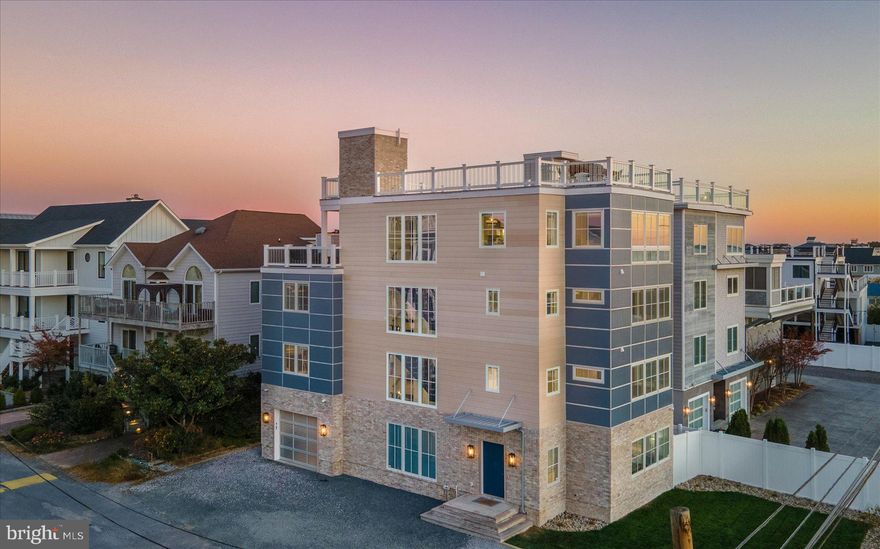 Introducing 40 Beach Avenue – a modern masterpiece on the ocean block of private North Indian Beach. This new home, crafted by Lane Builders in 2024, is being sold furnished and features 7 bedrooms, 7.5 baths, and 4200+/- square feet of finished indoor space spanning across 4 luxurious levels. What’s more, you’ll enjoy breathtaking views of the Rehoboth Bay and the Atlantic Ocean from your expansive Duradek rooftop deck. Every inch of this home has been customized to perfection, including custom millwork throughout, multiple wet bars, customized bathroom and kitchen cabinetry, and soft close cavity pocket doors. An upgraded lighting and electronics package by Overture Ultimate Home Electronics includes low voltage recessed lighting throughout, customizable keypads, Paradigm ceiling speakers on the fourth level, LED/OLED Sony TVs, and more. An elevator services every floor from the garage to the rooftop deck. The first level of the home features porcelain tile flooring throughout, a bedroom, bathroom with tiled shower, rec room, and wet bar with custom tile. A nod to the history of the North Indian Beach community is incorporated into the brick wall of the entryway – reclaimed from the original beach cottage that once stood on this lot. The second and third level each have 3 bedrooms with 3 ensuite bathrooms, a washer and dryer, and a tech station. The primary bathroom on the third level is wheelchair accessible with a zero-threshold shower. The living and dining area and the gourmet kitchen are on the fourth level of this state-of-the-art home – all with views of the Rehoboth Bay. The kitchen is a chef’s dream, featuring Vadara Quartz countertops with built-up edges, an 8-burner Wolf range, XO range hood, pot filler, Ruvati kitchen sinks, KitchenAid stainless steel refrigerator, microwave, wall oven, two dishwashers, a butler’s pantry and a full wet bar with ice maker, wine cooler and beverage refrigerator. There is also a powder room on this level. Steps from the kitchen is the fourth level Duradek deck with outdoor grill, refrigerator, and honed granite countertops. Follow the stairway to the best part of all – the rooftop deck with stunning views of Rehoboth Bay, Dewey Beach, and the Atlantic Ocean. With the unique allowance in North Indian Beach to build to a height of 42 feet, this home has an impressive advantage above and beyond those in neighboring Indian Beach and Dewey Beach, where 35 feet is the max. The rooftop deck has a stub for a future fire pit and wiring for outdoor speakers. It is also structurally sufficient to hold a hot tub. The garage in this home is not to be overlooked. It includes one of the three laundry stations in the home, sink with granite countertop and custom cabinetry, a drying rack, and True brand commercial-size ice machine to make filling up your beach cooler a breeze. It also houses the tank for your fire suppression system and a lead/lag booster pump to ensure consistent water pressure always flows within the home. This unbelievable home is being offered fully furnished and turn-key with high-end furnishings from Universal, Lexington, Fairfield Chair, John Thomas, Braxton Culler, Creative, and Legacy. All design work and furniture selections were done by Barbara Anderson Design and truly capture that high-end, coastal feel. Located in the intimate oceanside enclave of North Indian Beach, you’ll have access to a private, guarded beach and neighborhood security patrol. This community allows one-week rentals, meaning this property isn’t just an incredible coastal getaway for you as a primary or secondary home but also a valuable rental opportunity with the potential for $15,000 per week during prime summer weeks. Walk to everything Dewey Beach has to offer and then retreat to the calm oasis of North Indian Beach when you call 40 Beach Avenue your home away from home! Be sure to view the Drone Video and 3D Virtual Tour!