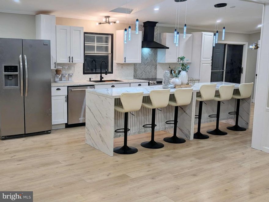 Welcome to this beautifully renovated 4-bedroom, 2-bath home offering 1,400 sq. ft. of comfortable one-level living. Step inside to an inviting open-concept layout, centered around a stunning oversized kitchen island that can easily seat up to 12 guests—perfect for gatherings, meals, and entertaining. The spacious living room features floor-to-ceiling bay windows, flooding the space with natural light and creating the perfect spot for this year’s Christmas tree. You'll also enjoy the new, stylish modern fireplace, adding warmth and charm on chilly nights. The kitchen showcases stainless steel appliances, an oversized stainless sink, and fresh modern finishes designed to impress while staying budget-friendly. Both bathrooms have been tastefully updated, including a tiled walk-in shower and sleek modern vanities that elevate the home’s contemporary feel. Step outside to a large rear deck overlooking a fenced-in private backyard, offering plenty of space for outdoor activities, pets, or relaxation. With its thoughtful upgrades, modern finishes, and generous living spaces, this home is truly move-in ready and designed for effortless, stylish living.