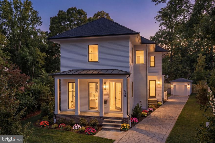 Tucked within the tree-lined streets of Ashton Heights and just moments from both downtown Clarendon and Ballston, 630 North Kenmore Street balances modern design with timeless elegance in one of Arlington’s most desirable neighborhoods. Developed by the Ventura Group, designed by GTM Architects, and with interiors by Kelly Knebel Designs, the home has been newly imagined from the ground up by an illustrious team of artisans.
 
The understated façade makes a subtle first impression, with white brick and Hardie Plank siding providing contrast against dark aluminum Marvin doors and windows. A deep paver driveway to the side is minimally intrusive and leads to a private detached garage at the rear of the property. The front entrance, tucked along a welcoming flagstone porch, opens into a dedicated reception area with a light-filled den positioned to one side.
An ethereal ambiance is enhanced by ten-foot ceilings and eight-foot doors on the main level, along with white oak hardwood flooring and substantial Emtek hardware throughout. Striking Visual Comfort and Hudson Valley light fixtures complement sleek WAC recessed lighting, adding visual interest and highlighting the clean architectural lines.
 
At the center of the main level is a grand stair hall, showcasing a sculptural white oak staircase with custom railings. Opposite the stair hall, the formal dining room is framed by a dramatic wall of glass and is thoughtfully scaled for elaborate entertaining. A butler’s pantry with wine fridge offers a seamless connection to the kitchen. A vestibule with powder and mud rooms bridges the transition between the formal and informal spaces.
 
The informal living areas span more than 30 feet in width, offering true open-concept flow. The family room features a gas fireplace and opens directly onto a covered rear flagstone screened-in porch, creating an ideal indoor-outdoor connection. Adjacent to the family room, the chef’s kitchen is a striking union of design and function. It features fully custom Alpine cabinetry, quartz countertops, and a full suite of Sub-Zero, Wolf, and Cove appliances. The adjoining breakfast area is bathed in natural light from three walls of glass.
 
Upstairs, the primary suite is a private retreat overlooking the rear lawn. Dual walk-in closets include extensive custom built-ins, and the spa-inspired bath offers radiant heated flooring, a curbless shower, a soaking tub, a double vanity, and a private water closet. Three additional bedrooms are well proportioned and feature private ensuite baths. A dedicated laundry room with full-size Electrolux appliances completes the upper level.
 
The lower level mirrors the scale of the main floor. A recreation area spans more than 30 feet in width and is anchored by a built-in bar with a wine fridge. A fifth bedroom with a walk-in closet and full bath, along with a fitness room, complete the space.
 
Technologically advanced and thoughtfully designed for the future, the home is pre-wired to accommodate a comprehensive smart home suite. Integrated features include ceiling-mounted surround sound speakers, wireless signal boosters on every level, and a robust video surveillance system.
 
The rear lawn unfolds as an immaculate green canvas, perfectly proportioned and thoughtfully irrigated, offering a refined backdrop for elegant outdoor living and entertaining.
 
Positioned just steps from the Orange Line Metro and minutes from Washington, DC, 630 North Kenmore Street blends exceptional craftsmanship, forward-thinking design, and a premier location. It is an inspiring example of modern urban living at its finest.