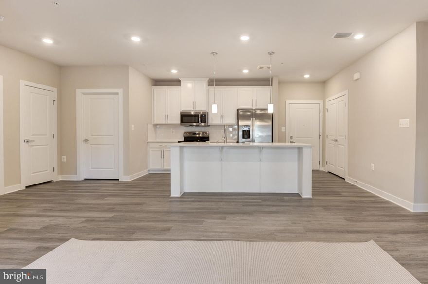 Previously it was a BUILDER MODEL home | Secured entrance to the building | 1,162 interior sq ft w/ 2 spacious bedrms & 2 full baths | One level living at its finest that accomplishes the right practical space in its sophisticated chic style | Unit located @ 2nd level | Bright, open floorplan opens to covered balcony (77 sq ft) that makes the whole living area an entertainment galore | This urban living  @ MOSAIC AT WOODLAND PARK community is perfectly tucked amidst to major roads access & tech companies | Showing by appointment only till Sep 30th | Secured underground garage parking (#22) in the same building | Beautiful LVP floors all thru the living areas | Modern kitchen w/ upgraded cabinets, humongous center island, quartz counters, SS appliances, backsplash & deep apron sink | Pantry | Pendent lights & Recessed lights | Magnificent owner's suite w/ large walk-in closet & spa feel featured bathroom; dual vanities & large shower area | Spacious secondary bedrm w/ hall bath | Laundry closet | Area rugs | Draperies | Eco programmable thermostat | Incredible prime location: An exceptional, convenient lifestyle w/ample nearby shopping, dining, fitness, studio-style gyms, movies, restaurants, meeting places &parks. Commuting is a dream w/ the Herndon Metro, Silver Line located just steps away (3/4 mile) Minutes to major routes like 267, 28 & Fairfax County Pkwy. Close to Dulles International Airport | Excellence in style, function & location.