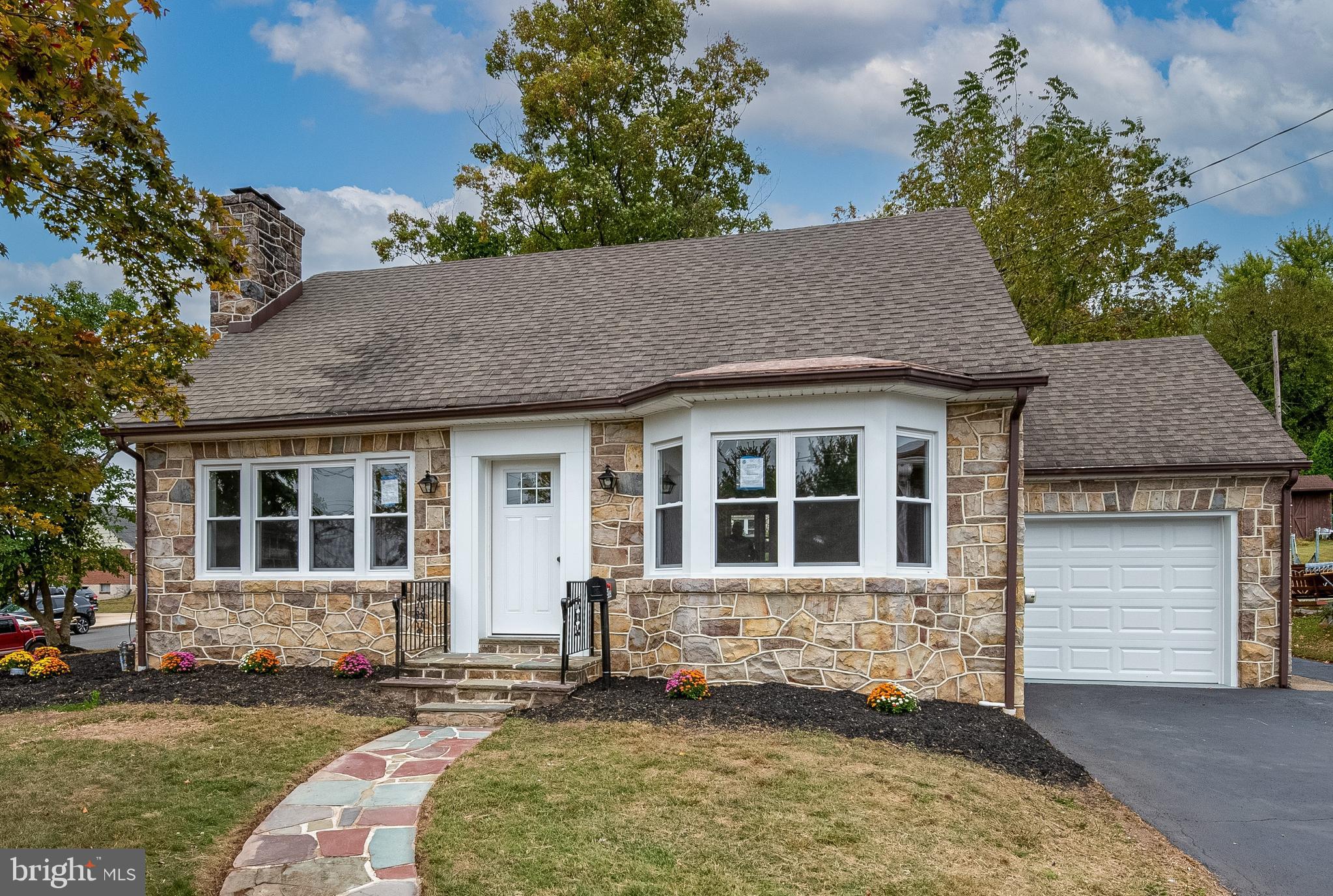 Welcome to this beautifully remodeled Cape Cod filled with charm and modern updates. Arranged on a corner lot with a large backyard and mature landscaping, this home has classic curb appeal with its slate walkways and solid stone exterior! Step inside to a spacious living room with a large picture window providing plenty of natural light and a cozy wood-burning fireplace. A formal dining room with bow window adds elegance and more natural light. Brand new kitchen boasts granite countertops, tile backsplash, soft-close drawers, and under-mount lighting. A door in the kitchen leads out to a covered slate side porch, the perfect spot to enjoy your morning coffee. Upstairs, you will find two generously sized bedrooms, both with walk-in closets. An updated tiled full bath completes the upper level. The lower level provides flexible living space with two finished rooms that could be used as a third bedroom, family room, or office. There is a new full bath with tiled shower in the lower level. Stylish vinyl plank flooring throughout the home for easy maintenance, and a one-car detached garage. This move-in ready home won’t last long!!