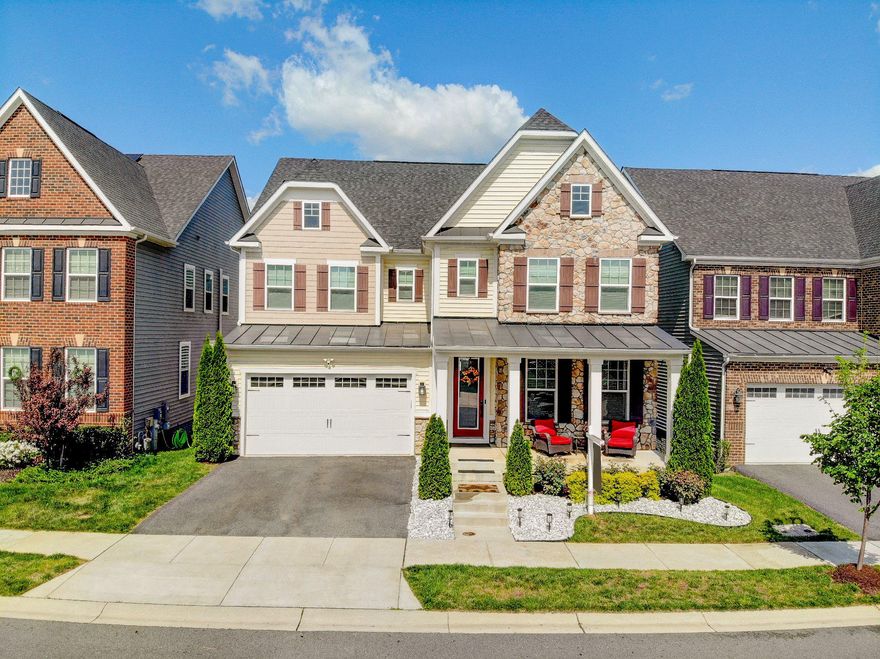 Welcome to this stunning home nestled in the highly sought-after Two Rivers community. This beautifully appointed residence offers the perfect blend of luxury, comfort, and convenience.

Step inside to an expansive living and dining room, ideal for entertaining and accommodating a generously sized table. The open-concept layout continues into the spacious family room, kitchen, and dining nook—anchored by a custom gas fireplace that adds warmth and charm.

The gourmet kitchen is a true showstopper, featuring quartz countertops, crisp white cabinetry, stainless steel appliances, a stylish tile backsplash, and an oversized island with sink—perfect for meal prep and gathering. Natural light floods the space, with serene views of the surrounding green space. Step outside onto the deck to enjoy peaceful sunset views.

Upstairs, a versatile loft provides the perfect retreat for relaxation or a quiet workspace. The luxurious primary suite features tray ceilings, dual closets, and a beautifully designed en-suite bath complete with a soaking tub, walk-in shower, and two separate vanities.

The fully finished walk-out basement is an entertainer’s dream, offering a spacious rec room and an impressive custom bar with backlit display cabinetry, sink, and dual beverage refrigerators. A full bathroom completes this level.

Conveniently located just half a mile from Two Rivers Elementary School, this home combines suburban tranquility with exceptional accessibility—just 10 minutes to Wegmans, 15 minutes to the Odenton MARC Station, and within 20 minutes of downtown Annapolis and the DC Metro.

Residents of Two Rivers enjoy resort-style amenities, including a clubhouse, pool, fitness center, tennis and sports courts, community gardens, parks, playgrounds, and scenic trails.