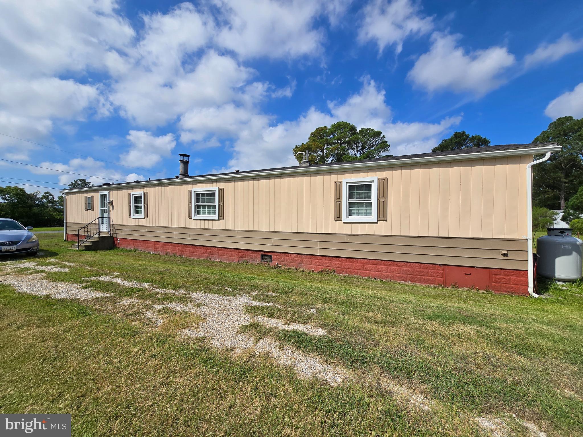 Cute as a button, single wide mobile home located outside city limits of Crisfield with public water and sewer. Home was remodeled in 2015, with house type thermopane windows and laminate floors throughout. Home is in excellent shape. Open floor plan makes it feel so much bigger. Large living room with corner gas fireplace and wood look exposed beams. Off the living room is the master bedroom with large walk in closet and master bath. The kitchen had plenty of room for your dining room table. Off the kitchen is the 2nd bedroom with its full bathroom. Nice size yard with small deck to sit on. There is a Large 12'x20' garage/storage building that is big enough to park a car. Convenient location for shopping and recreational facilities, within walking distance to public beach and fishing pier.
