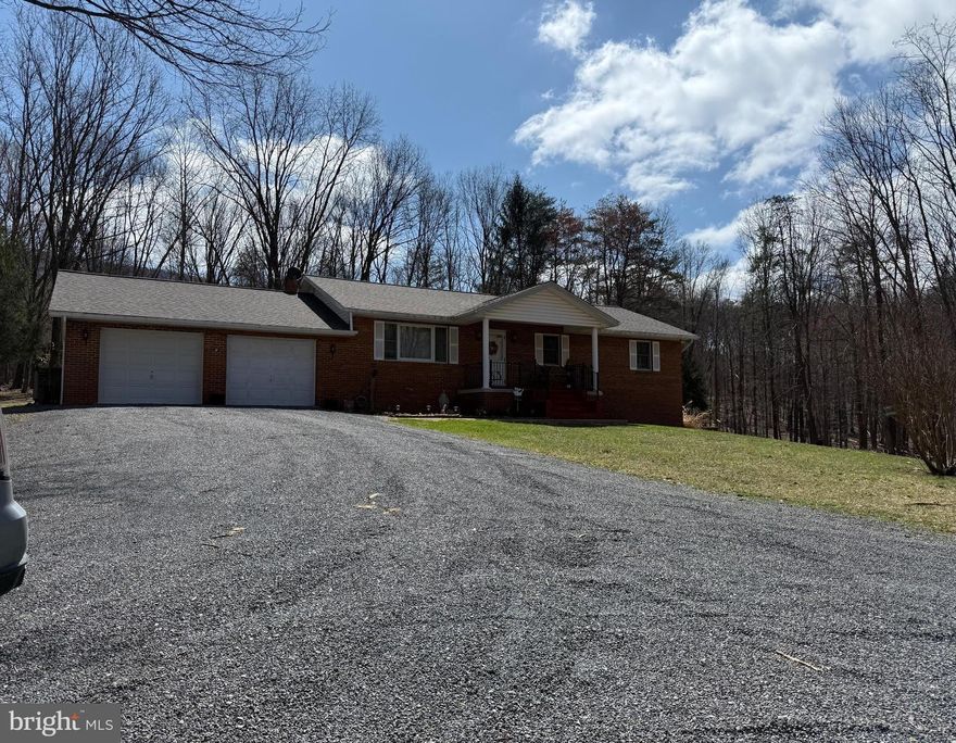 Brick Rancher situated on 3.11 private acres.   Home features:  Kitchen - Dining Room with glass doors onto covered porch overlooking this beautiful wooded setting.    Living Room, 3 Bedrooms, 2 Baths Plus a finished basement.