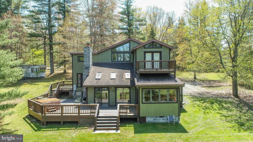 2.3-acre lakefront on the quiet side of Deep Creek. 152 feet of private shoreline with a Type A dock. Main home has four bedrooms, three full baths, and a simple open layout built for easy living. Wood-burning stone fireplace. Wall of glass facing the lake. Natural light all day. Large deck off the back. Flat yard to the water. No stairs. No noise. Second dwelling on-site—grandfathered trailer with full septic, ready for a guest house, rental, or workspace. Plenty of parking. No HOA. Located minutes from Thousand Acres Golf and a short drive to dining and marinas. Solid setup for full-time living or second-home retreat. Clean, private, usable land. Waterfront done right. Call today for details!