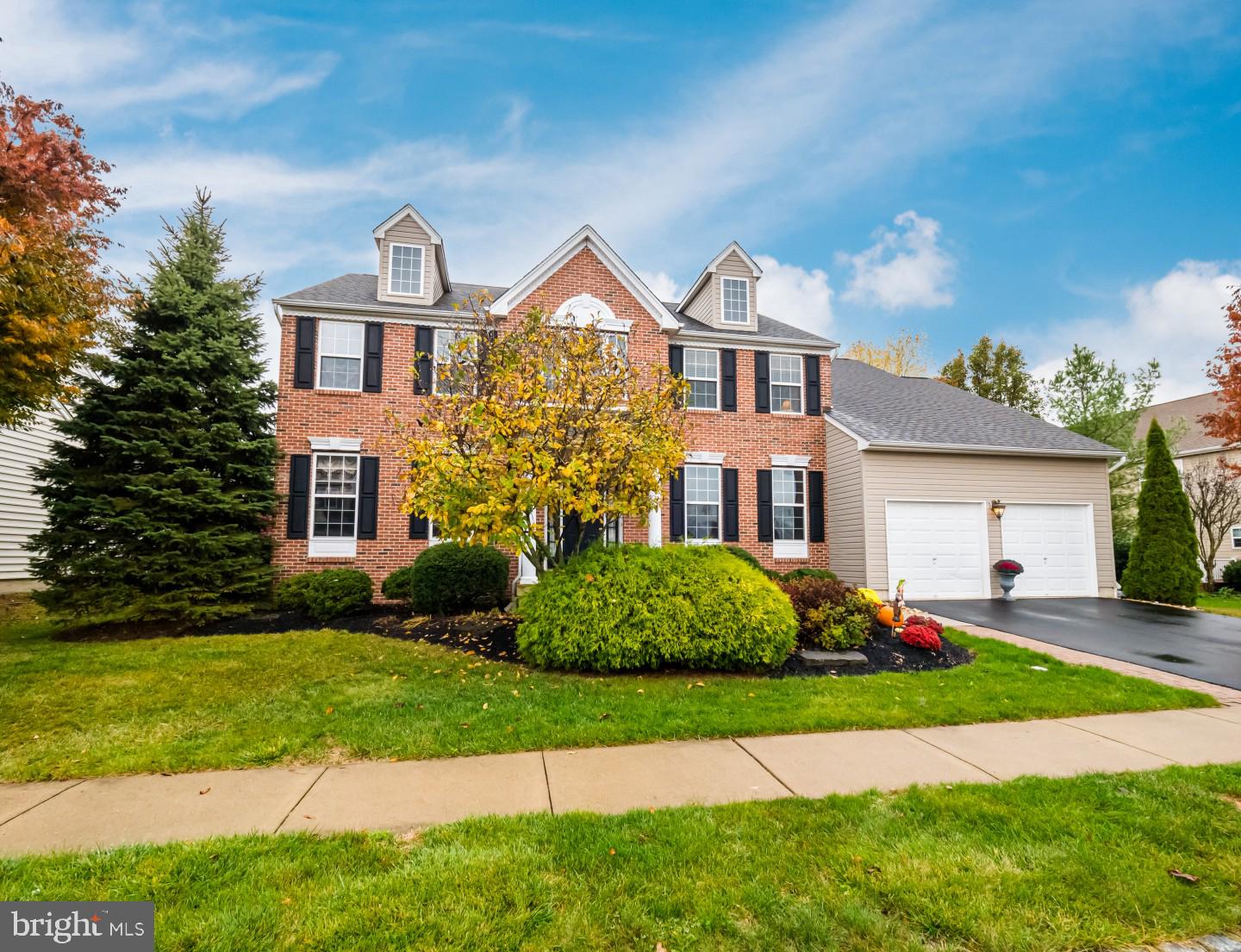 Welcome to 246 Pennland Farm Drive, a stately brick front colonial in a sidewalk-lined neighborhood that backs to open land. This four-bedroom home features two and a half baths, a finished basement and great outdoor living. From the landscaped, covered entry you step into a bright two-story foyer with hardwood floors and shadowbox wood trim. An office affords an executive or entrepreneur a quiet workspace with recessed lighting and vintage decor. The formal living room invites you to have conversation as the wide crown molding, plush carpeting and soft infusion of natural light create an elegant ambiance. Allowing for an effortless flow when entertaining, the dining room reveals a tiered tray ceiling, two tone appeal and extensive wood trim. The kitchen is adjoined by a causal dining area with sliding glass doors and enjoys sightlines to the fireplace in the family room. The chef will appreciate the distinctive design elements of this workspace including mosaic detail in the backsplash, cabinetry topped with crown molding, breakfast bar center island, divided sink basin, stainless steel appliances, double pantry and a built-in desk area. The fireplace with surround that stretches to the ceiling is a comfortable gathering space. Accent lighting will highlight your favorite piece of art and multiple windows allow for natural light throughout the day. A sizable laundry room with extra organized storage and a powder room complete this level. You can create a lovely sitting nook overlooking the foyer as the open hall connects four bedrooms and two full baths. Double doors take you to the master suite where the thoughtful design includes his-and- her walk-in closets, a bedroom area with pitched ceiling for extra spaciousness, and sitting area with bank of windows. The ensuite bath affords a double vanity, oversized medicine cabinet behind bypass mirrors, a soaking tub and glass shower. Three nicely size bedrooms all have plenty of natural light, double closets and share the common bath with dual sinks. The lower level has two rooms for recreational activity, walk-out access through bilco doors plus a plethora of storage so you can keep the garages clear for parking. Framed with a curved stone wall the patio gives you direct views of the open space behind the property tree line that is dotted with evergreens for year-round color and the opportunity to see numerous song birds. Major nearby roadways provide easy commutes to Allentown, New Jersey or Philadelphia. Make this beautifully maintained home yours today!