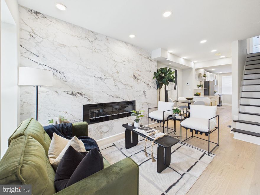 Welcome to Baltimore City Luxury Living! Just minutes from John’s Hopkins, this beautiful 3 level  rowhome boasts custom living on every floor! As you enter, you’re greeted in the living area by an expansive floor to ceiling ceramic tiled fireplace wall. The gourmet kitchen features stainless steel appliances, upgraded quartz countertops and a custom LED screened faucet that shows the temperature of the water and keeps track of how long it’s been running! Complete with a half bath, and designated dining room with GIMBAL lighting, this main level is truly captivating. The second floor hosts 2 generous sized bedrooms. The primary suite features a one of a kind tile slat fireplace, custom ceiling fan, walk in closet with an organizer and an oversized shower with 10ft floor to ceiling surround tile! The fully finished basement has an additional bedroom with a custom wood fireplace and a full bath! One Year Home Warranty! Schedule your private showing TODAY!