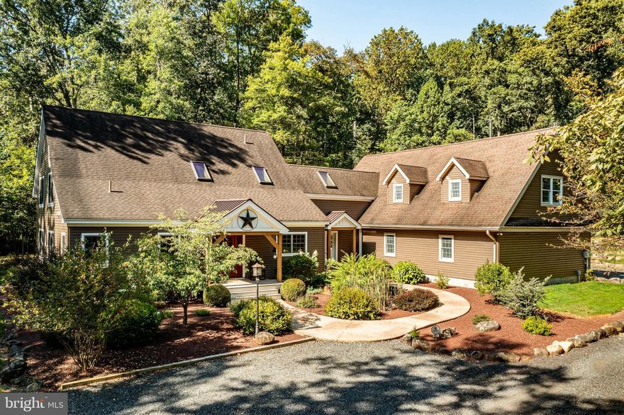 Welcome to this exceptional one-of-a-kind custom home, nestled on nearly 5 peaceful wooded acres in the scenic countryside of Montgomery County. Located within the highly rated Boyertown Area School District, this architectural masterpiece combines classic craftsmanship with the highest standards of energy efficiency and comfort.
Constructed by the renowned Davis Timber Frame Company, the home features authentic mortise-and-tenon joinery and high-performance Murus structural insulated panels—delivering extraordinary strength, insulation, and timeless design.
Step inside to discover over 4,500 square feet of beautifully appointed living space. Exposed timbers and soaring ceilings create an atmosphere of elegance and warmth, while wide-plank rough-sawn wood floors, custom cherry cabinetry, and Bucks County soapstone and granite countertops highlight the home’s artisanal finishes. The chef’s kitchen is both functional and refined, flowing seamlessly into inviting dining and living areas anchored by a Jøtul wood stove. Walls of windows frame serene wooded views, bathing the interiors in natural light.
The first-floor primary suite offers luxurious privacy with a spacious walk-in closet and spa-style double-head walk-in shower. Upstairs, two bedrooms provide flexibility and comfort, while the finished lower level includes lots of  flex space to watch movies, exercise or play games,  bilco doors and the 4th bedroom/office—perfect for today’s dynamic lifestyle.
Energy efficiency is prioritized with high-efficiency mini-split heating and cooling units in every room, a Rinnai tankless water heater, and a whole-house Energy Recovery Ventilation (ERV) system for fresh, balanced air. Additional upgrades include CAT 5 wiring, Vector Security alarm, private well & septic, and underground utilities for a clean exterior aesthetic.
Step outside to your oversized 3-car garage (28’ × 40’)—easily accommodates three large vehicles with abundant room for a workshop or storage.  Above the garage is the fully equipped 1,200 sq ft in-law suite above featuring radiant floor heating, central air, an independent oil furnace, wood-burning stove, and private entrance with a 12’ × 12’ deck for tranquil mornings overlooking the back of the property. From inside, access is provided through a spiral staircase in the finished breezeway, with the design offering the flexibility to easily convert the staircase area to a residential elevator for long-term accessibility. Whether you need multi-generational living, a dedicated guest space, or a quiet home office retreat, this suite delivers flexibility and privacy.
Situated on 4.92 wooded acres, the property offers privacy, natural beauty, and abundant opportunities for outdoor living. Whether you dream of gardens, entertaining patios, or simply enjoying peaceful walks through the trees, this estate provides the perfect backdrop. Located within the Boyertown Area School District, it combines tranquility with convenience to local communities and commuter routes.
661 Henning Rd is more than a residence—it’s a lifestyle. Combining artisan timber framing, advanced building systems, and flexible living arrangements, this property is a rare opportunity to own a home of unmatched quality and character in Montgomery County.