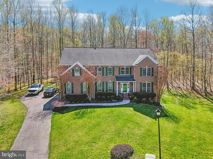 Grand Estate Living at 2801 Scenic Meadow Street, Waldorf

Welcome to 2801 Scenic Meadow Street—a true hidden gem tucked away in an exclusive cul-de-sac, offering the perfect blend of elegance, privacy, and space. Set on over half an acre, this stately residence provides rare separation between homes and a serene setting ideal for luxurious living.

A long, picturesque driveway leads you to beautifully manicured landscaping that sets the tone for what awaits inside. Step onto the welcoming front porch and through the grand entrance, where rich hardwood floors flow throughout the foyer, formal living room, dining room, and gourmet kitchen.

To your right, the formal living room impresses with tray ceilings, intricate crown and chair moldings, and classic Greek columns—an ideal space for sophisticated entertaining. To your left, a gracious formal dining room awaits, perfect for hosting elegant dinners and holiday gatherings.

The heart of the home is the sprawling chef’s kitchen, outfitted with new slate appliances, granite countertops, a complementary backsplash, and an expansive island with bar seating under designer pendant lighting. Endless cabinet space and a cozy breakfast nook make this kitchen both functional and stylish. Just off the kitchen, a sun-drenched morning room surrounded by windows offers peaceful views and direct access to the outdoor deck.

The oversized family room delivers on both scale and warmth with a focal-point fireplace, custom mantel, and recessed lighting throughout. Need a home office? A dedicated office space with panoramic windows and a skylight provides an inspiring place to work, complete with pocket doors for privacy and efficiency.

Upstairs, luxury continues with five generously sized bedrooms. The primary suite is a true retreat—featuring soaring cathedral ceilings, a separate sitting area, and a spa-style bathroom with a dual-sink vanity, jacuzzi tub, separate shower, and skylight. A secondary guest suite with a private full bath ensures visitors feel right at home. Three additional bedrooms and a third full bath, along with a spacious upstairs laundry room, round out the upper level.

The finished lower level offers even more flexibility and luxury. Host unforgettable movie nights in the dedicated home theater, enjoy the recreation space ideal for a game room or future bar area, and utilize a bonus room for fitness or a second office. A full bedroom and full bathroom on this level make it ideal for guests or multigenerational living. There’s also a walkout to the backyard for seamless indoor-outdoor flow.

The backyard is a private resort-style escape, complete with a two-level maintenance-free deck, a fully functional hot tub, and a stunning stone patio with built-in fireplace. Backing to mature trees, this tranquil setting offers the ultimate in outdoor living and entertaining.

Additional features include a two-car side-entry garage, exterior security cameras, and a spacious double-door shed ideal for storing a riding lawn mower or garden equipment.

If you’ve been searching for a truly expansive, upscale home with every amenity—your search ends here.