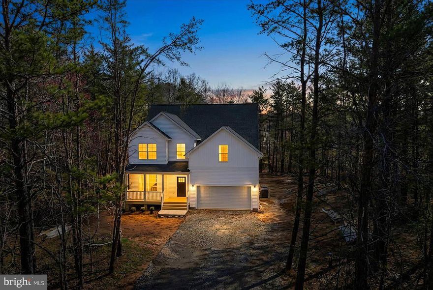 Welcome to The Madison by Danaf Homes — a brand-new, thoughtfully designed home in the sought-after water-access community of Wildwood at Lake Anna, where everyday life feels like a vacation and spontaneous lake days are practically mandatory. With a scheduled January delivery, this stunning residence offers 4 bedrooms, 3 bathrooms, an open loft, and over 3000 square feet of beautifully upgraded living space on a private lot just minutes from waterfront dining, wineries, and all the local lake fun the public side is known for. Step inside and follow the flow of luxury vinyl plank flooring throughout the main level and bedrooms, setting a seamless foundation for modern living. The family room features a gorgeous propane fireplace with a designer slate surround and stylish mantel — the perfect heart-of-home for cozy evenings after a day on the water. The chef-inspired kitchen checks every box: sparkling quartz countertops, an oversized island, upgraded stainless appliances including a Whirlpool dishwasher, range, and microwave hood combo, a white farmhouse-style apron-front sink, and Aristokraft cabinetry finished in a crisp white with accents at the island — all elevated with matte black fixtures and cabinet hardware for a clean designer finish. From here, the dining area opens to the backyard, offering the ideal layout for indoor-outdoor entertaining — think future firepit gatherings and sunset dinners under the stars. Your primary suite is a lake-life sanctuary featuring a spacious layout, walk-in closet, quartz dual-sink vanity, upgraded framed mirrors, a large tiled shower with matte black glass door trim, and a relaxing soaker tub. A  main-level bedroom with full bathroom access offers flexibility for guests, aging-in-place, or a quiet home office. Upstairs, the loft provides endless possibilities for movie nights, a play zone, or fitness space — all accompanied by two generously sized bedrooms and another upgraded full bath. Stylish craftsman trim, upgraded matte black lighting and hardware, quartz counters in every bathroom, and designer interior selections add curated warmth and sophistication throughout. Even the details outside matter: insulated garage door with opener and keypad, clean white siding with complementary accents, and sleek Maxim outdoor lighting elevate curb appeal from day one. Most importantly — say hello to lake access: Wildwood offers a private community boat launch and leased slips so boating, kayaking, paddleboarding, and every lake adventure is right at your fingertips. Whether you’re seeking a full-time residence, a weekend retreat, or a smart investment opportunity in one of Virginia’s most desirable lake communities, The Madison delivers the perfect harmony of luxury, comfort, and lakeside living. Life happens everywhere — but the good life happens here.