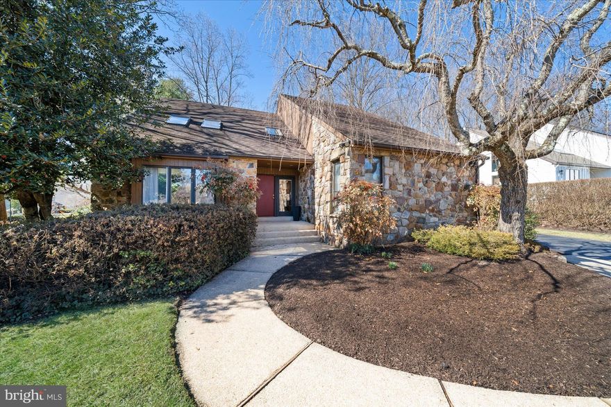 Welcome to Fairthorne, a highly desirable Greenville community. This sun-filled, 3-bedroom, 2.5-bathroom home features contemporary architecture that blends seamlessly with today’s modern lifestyle. The dramatic entry and grand two-story foyer set the stage for an inviting, open-concept floor plan where vaulted ceilings and large skylights create a bright, airy atmosphere throughout. The main level is designed for entertaining, with a living room that opens to both the dining area and a bright sunroom. At the heart of the home, the kitchen overlooks a spacious family room featuring custom built-ins and a beautiful gas fireplace with stone surround. Both the sunroom and family room provide access to a large deck, complete with an awning for comfortable outdoor enjoyment. This level is completed by a powder room and a luxurious primary bedroom suite, which boasts a large walk-in closet and a renovated bathroom featuring a dual vanity and a marble-tiled walk-in shower. The upper level offers two additional bedrooms, a full bathroom, and a versatile loft space—perfect for a home office or overnight guests. Situated on a professionally landscaped corner lot, the property features mature trees and serene views of the wooded open space beyond the rear yard. We invite you to tour this exceptional home today!