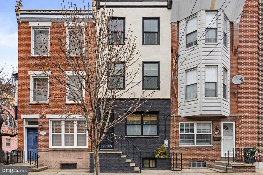 Welcome to 917 Catharine Street, a rare and beautifully renovated Bella Vista residence completed in 2022, offering a level of finish and thoughtful design throughout. The sun-filled first floor showcases original inlay hardwood floors and an open living and dining layout that feels warm, open, and effortless. The kitchen is a true focal point, featuring custom cabinetry, quartz countertops, stainless steel appliances, a farmhouse sink, classic white tile backsplash, open shelving, brass hardware, a drawer-style microwave, and a built-in coffee nook. Just beyond, a spacious private patio provides an ideal setting for morning coffee or outdoor dining, with the added convenience of a breezeway offering secondary access and everyday functionality. The second level offers two spacious bedrooms and a serene hall bathroom with a marble-topped vanity, a deep soaking tub with a tub/shower combo, crisp white subway tile, and a window that fills the space with natural light. The middle bedroom includes a thoughtfully added den-style flex space, perfect for a home office or workout area, while the south-facing front bedroom is bright and airy with generous closet space. The entire third floor is dedicated to a stunning primary suite featuring a sun-drenched south-facing bedroom, an oversized walk-in closet, and a spa-like en-suite bathroom with a seamless glass shower, brass fixtures, and a custom dual-sink vanity. A fully finished basement adds even more versatility with side-by-side laundry and space for a home gym, playroom, or additional storage. Beyond its beautiful finishes, the home offers peace of mind with major system upgrades, including a brand-new HVAC system with Google Nest thermostats, a new hot water heater, all-new plumbing fixtures, and a fully updated electrical system with smart switches. All windows throughout the home were replaced, and exterior improvements include a refreshed front façade, repointed and painted brickwork, and back exterior stairs and patio tile, making this a truly move-in-ready offering. Set in one of Bella Vista’s most sought-after locations, this home places you just steps from Philadelphia favorites, including Bart’s Bagels, Pop’s Bun Shop, Mawn, Sarcone’s, Ralph’s, Angelo’s, Isgro’s, Fiorella, Alice, and the Italian Market, with Whole Foods only a short walk away. Do not miss the opportunity to make this stunning Bella Vista residence your home!!