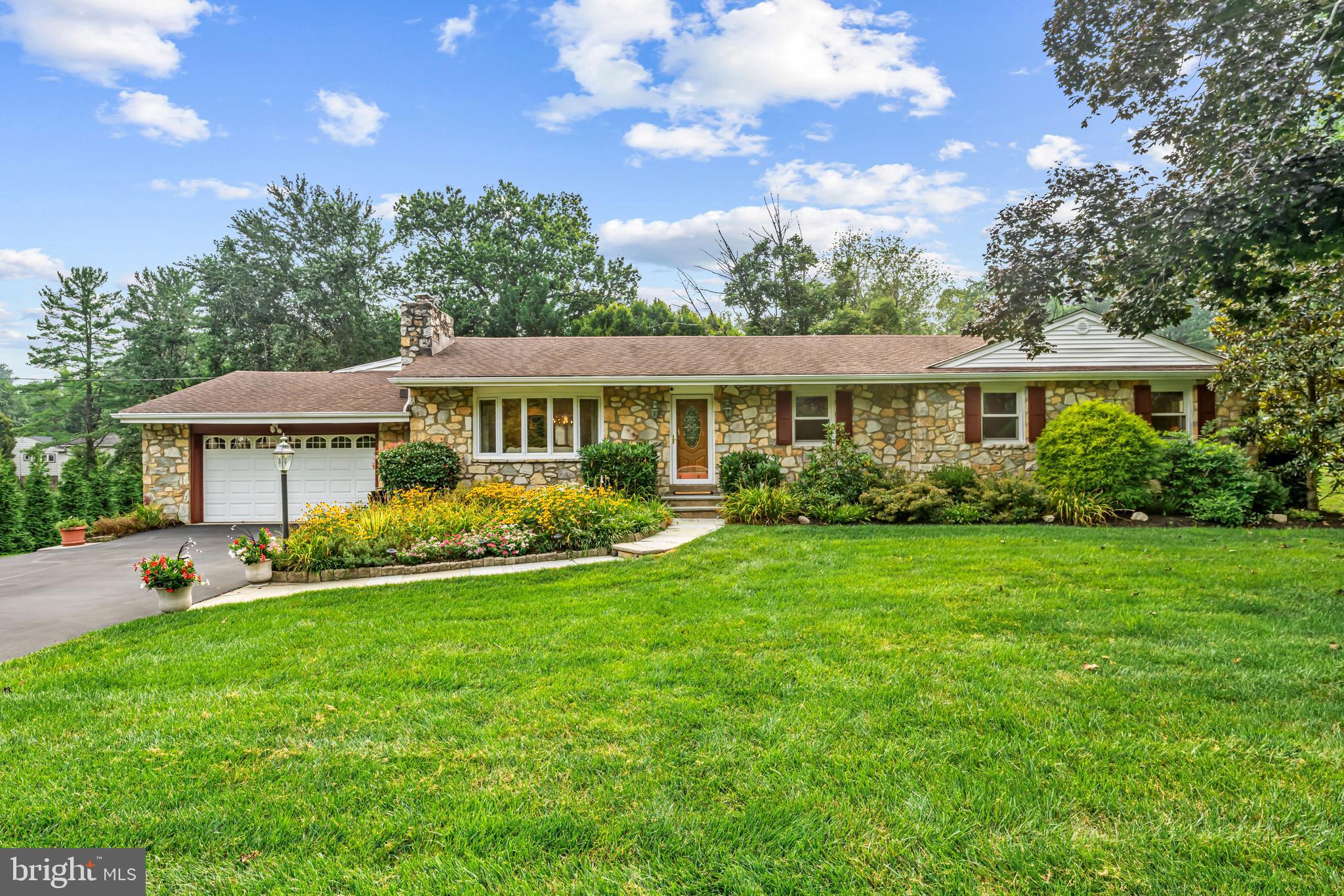 Rarely does a stone ranch home become available in sought-after Villanova, and this gem is ideally situated on a quiet street in a premier location—just minutes from everywhere you need to be! Set on a flat, beautifully landscaped lot, this gracious home features lush green grass and a flagstone walkway that leads through manicured front gardens to a welcoming center foyer. Inside, you'll find a spacious living room filled with natural light from a large bay window, enhanced by recessed lighting, in-wall speakers, and a cozy gas fireplace. The adjacent dining room is perfect for hosting gatherings, complete with a built-in banquet offering abundant storage. The updated kitchen boasts granite countertops, soft-close wood cabinetry doors, and gas cooking. An ideal spot for any home chef. Just beyond, a private rear deck provides a serene space for alfresco dining and relaxing on pleasant days. A versatile family room includes built-in bookshelves, access to the attached two-car garage, and leads to a bonus room which is perfect as a home office or den. Down the hall, the primary suite offers an expanded footprint with a large walk-in closet and an en-suite bath with a walk-in shower. Two additional well-sized bedrooms share an updated hall bath with a tub. The full, walk-out lower level is partially finished and incredibly functional. It offers a fourth bedroom, full bathroom, gaming/hangout area, laundry room, a large cedar closet, and two generous storage rooms. Outside, a walk-in shed conveniently located beneath the family room and accessible only from the exterior. This room provides additional storage for tools and outdoor furniture and gear, keeping your garage free for vehicles. This home is a true find—offering an abundance of square footage, flexibility, and future potential. Whether you move right in or plan to expand over time, this Villanova ranch is a fantastic value in an unbeatable location.