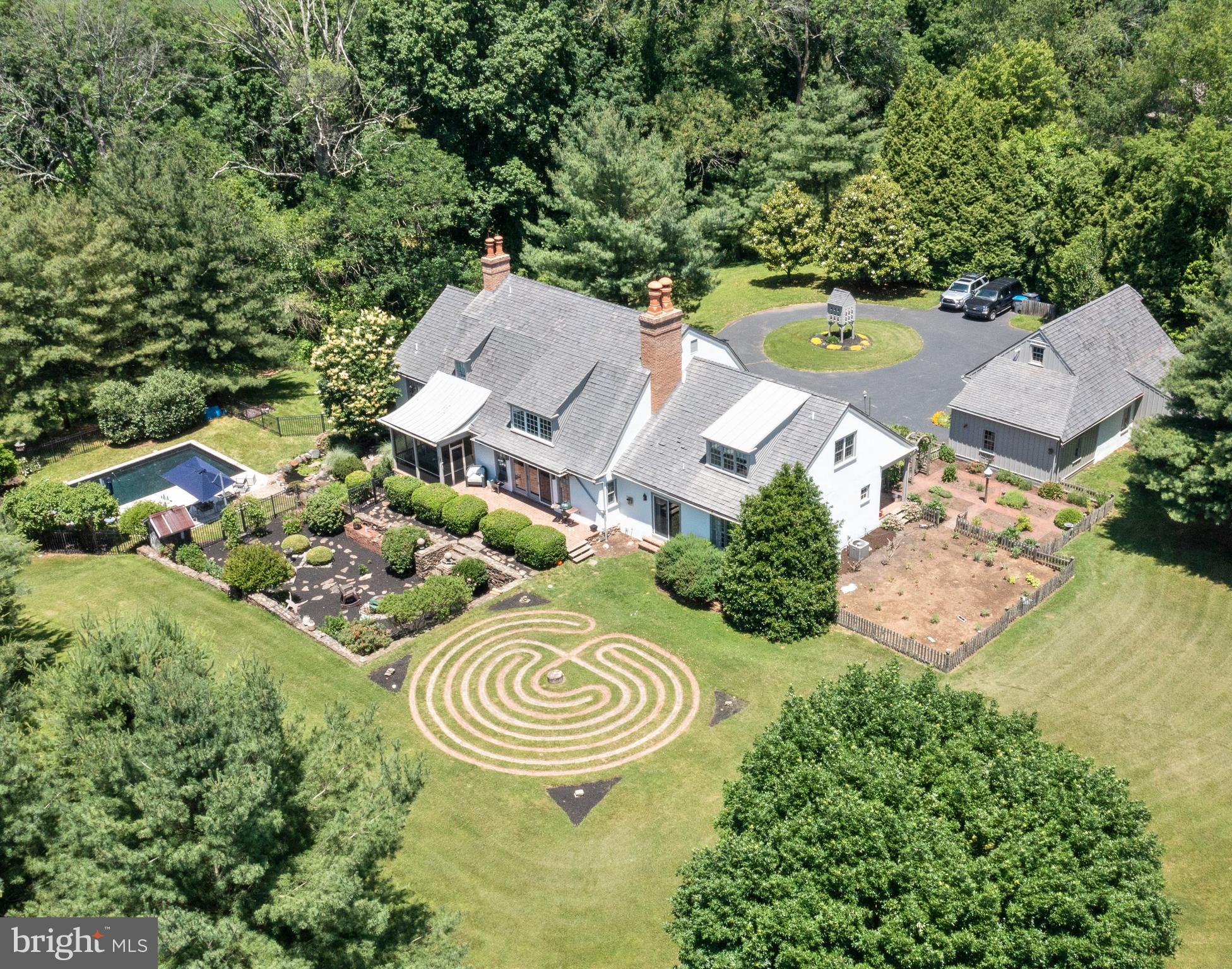 Custom Built English Manor Country Home set on a private and serene 5.8 acres in Birmingham Township. A long lane leads you to a circular drive and this spectacular home with exquisite gardens, pool and a one of a kind labyrinth. Reclaimed random width flooring, barn beams, custom millwork and reproduction hardware and lighting throughout are just some of the special features of this home. A brick floor entrance opens to a spacious great room with a two story vaulted ceiling and a walk-in stone fireplace. Off the great room is a screened in porch with mahogany trimmed panels large enough for both dining and relaxing while you enjoy the outdoors. Enjoy views of the gardens, pool and a small Koi pond with waterfall. A triple slider opens up the great room to a brick patio and a large reproduction barn foundation with extensive plantings and a fire pit! The gourmet kitchen is open to the great room and offers custom maple cabinets, soapstone island, leathered granite countertops and high end appliances. Off the kitchen is a large mudroom area with two walk-in pantries, a third shelved closet, storage bench and a second entrance giving access to the front gardens and the three car detached garage. Adjoining the great room is an office/sitting room or potential dining room lined with built-in bookshelves and a gas fireplace. The primary bedroom suite is on the main floor and has a gas fireplace and hall with two walk-in closets and laundry. The remodeled primary bath has radiant heat flooring, soaking tub, large shower and double sinks. Your own separate wing! On the other side of the great room is another separate "wing" with a bedroom, full bath, study with gas fireplace, mini-kitchen area and its own separate entrance, the perfect in-law suite. On the second floor are two additional bedroom "wings" each with hall bath and closets. There is a fifth bedroom in the middle of the two wings over looking the great room and beyond to the gardens. A walkout lower level has a large finished area with built-in cherry cabinets, storage closets and a large unfinished area for additional storage. This property offers breathtaking views of the countryside along with stream access. Great location with easy access to major routes, restaurants, shopping and Unionville-Chadds Ford Schools!!
