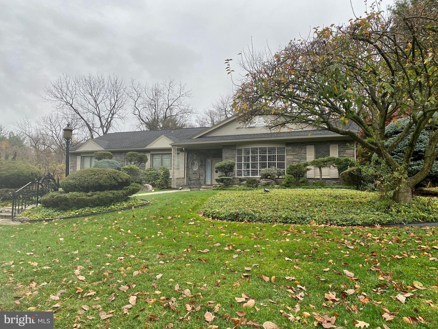 Presenting a gorgeous stone ranch on one of the most beautiful streets in Elkins Park. This home features 4 bedrooms, 2 full baths and 2 half baths, and over 3000 sf . Upon entering this grande residence you will be wowed by the enormous rooms and attention to detail. Many equisite leaded picture windows overlook the .5 acre parklike setting. Some details include: walk-in pantry, breakfast room, den with built-ins and walk out onto a covered stone patio with mercer tile and fret iron work, designer inspired painted ceilings, hardware and moldings, triple fitted closets in bedrooms, primary bedroom with walk-out terrace and bathroom featuring fitted closets and built-in vanity. The lower level of the home is fully finished with plenty of storage and a wet bar/soda fountain, perfect for entertaining! A 3-car oversized garage with storage closet completes the interior of this home. The professional landscaping encompasses patios and a gazebo in a setting you won't want to leave. This home is truly a gem!