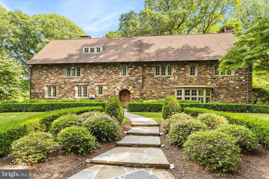 Welcome to North Hill, an exquisite stone English Cotswold Manor home built by the Hire’s Root Beer Family in 1924.  This home is perfectly perched high and tucked away from the road.  Enter the driveway and admire how North Hill sits on a lush 1.2 acres in Tredyffrin Township.   Undoubtedly, the first thing you will notice is the beautiful stone exterior of this home.  It is said that Mrs. Hires went to the quarry to hand pick every stone.  When you enter the front door you will notice the incredibly thick wooden arched door and the craftsmanship that has been in use for nearly 100 years.  The center hall greets you with rich hardwood flooring, a grand staircase with second floor landing and a rear glass atrium style doors that lead out to the large rear stone patio.   Just beyond the foyer is the immense formal living room.  The room is a step down to a fantastic space with random width hardwood floors, built-in bookshelves and drawers, a large bow window seat and a beautiful wood beam ceiling.  There is a fireplace with warming benches and built-in shelving and handmade Mercer tile from Doylestown.  The tile has all the zodiac signs mixed in for you to find.  The wooden mantel above the fireplace has a story of Mrs. Hires carved into the underside and the wooden faces of the builders which shows all the emotions (happy, sad, etc.) during construction.  This room is large enough to provide many areas that can serve multiple purposes or use the entire room for grand events.  Adjacent to the living room is the solarium.  This room is a haven for relaxation with nature.  It features glass and stone walls with metal glass doors to rear patio and yard.  The stone walls feature large wooden barn support beams and there is an original wall sconce that adds warmth and character.  Return to the center hall and take the rear hallway to the stunning family and dining room.  This room is perfect for smaller gatherings.  The cathedral wood ceiling captures’ your eye with its magnificent wood beams and rich wooden hue of the ceiling.  The kitchen is newer with timeless white cabinetry, granite countertops, built-in fridge and freezer and a large island with plenty of seating for those to gather while making meals.  The butler pantry is fully equipped with floor-to-ceiling China cabinets and plenty of pantry closets.  Additionally, find a double stainless-steel sink with two built-in wooden drain boards and access to the back staircase.  Upstairs on the second floor, there is a large primary bedroom with fireplace, balcony window, private access to full bath and dressing room.   Down the hall find a sleeping balcony which is currently being used as an in-home office/study.  There are two more bedrooms each with fireplaces that share a hall bathroom with more of the custom-made Mercer tile which is handmade Mission/Spanish revival style. It is timeless and a true work of art.  On the third floor there are two more spacious bedrooms each with their own ensuite baths.   The lower level is full and mostly unfinished.  There is a lower-level laundry room with a half bath and access to the side load 3 car garage.   Walk to schools, train, shops, Chester Valley Trail and so much more!    This home is in good working condition and is being sold as-is, several new upgrades can be made with a home of this era.  In the meantime, this one-of-a-kind estate home has been masterfully maintained and ready for new owners to take it to the next level.  
(DO NOT DRIVE UP DRIVEWAY WITHOUT AN APPOINTMENT)