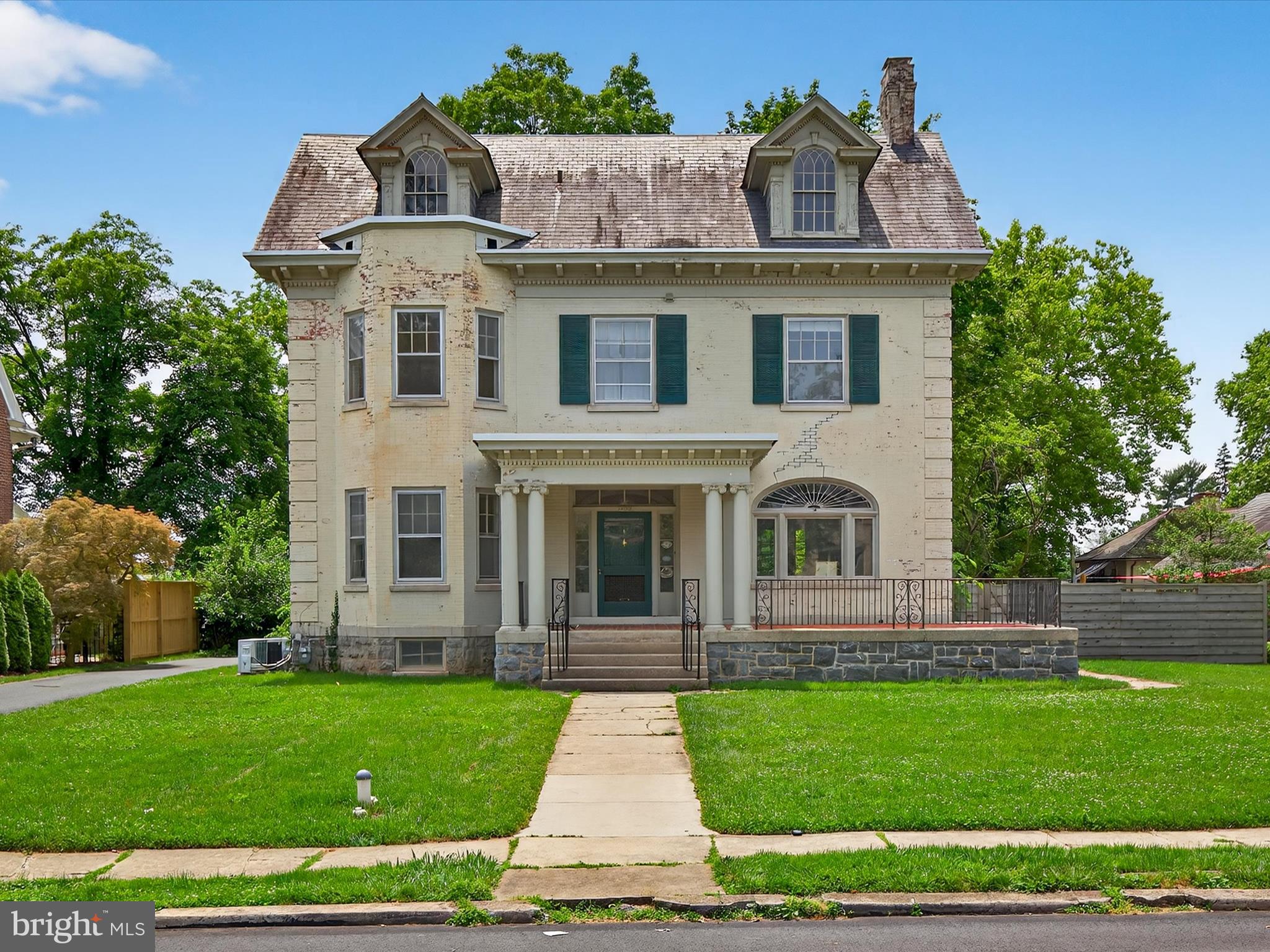 Step into a bygone era with this stately Colonial Revival residence, prominently situated in Lancaster’s prestigious School Lane Hills neighborhood. Brimming with original character, this expansive home offers a rare opportunity to restore and reimagine a classic estate just minutes from the heart of Lancaster City.
From the moment you arrive, the grand façade, complete with brick detailing, green shutters, and columned entry, sets the tone for the elegance within. Inside, high ceilings, hardwood flooring, and ornate woodwork carry throughout the home, complemented by tall windows that flood the space with natural light. The gracious living room features a marble fireplace and period trim, perfect for entertaining or relaxing in timeless style.
The home boasts multiple gathering spaces including a formal dining room with a bay window and a sweeping central staircase that speaks to the home's historic charm. While the kitchen is in need of renovation, it offers generous dimensions and abundant light—ideal for customizing your dream culinary space.
Upstairs, generously sized bedrooms include original architectural touches and a second fireplace. Additional storage and functionality are found in the large unfinished basement.
Outdoors, the property showcases a deep fenced yard with mature trees, a garden area, and a charming detached carriage house with garage bays and upper-level storage. A private driveway provides ample off-street parking.
Located just a stone’s throw from Buchanan Park, Franklin & Marshall College, and Lancaster Country Day School, this home offers proximity to vibrant downtown restaurants, Central Market, and cultural venues, while still enjoying the tranquility of a tree-lined neighborhood.