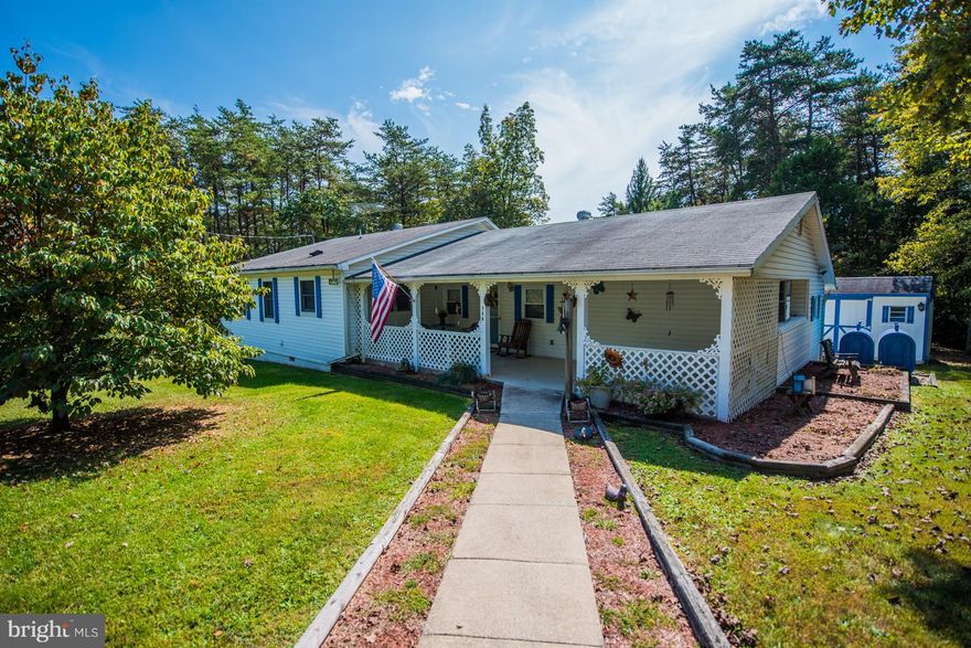 Bright and welcoming, This well kept home and property is set up for easy living.2 bedrooms 2 full baths one with walk through jetted tub, full kitchen with attached dinning. 2 Large living areas with wood burning fireplace, den / hobby area, central air and heat. level partly wooded lot with paved drive and Large 2 car garage / work shop. Started as mobile home so financing is very limited.