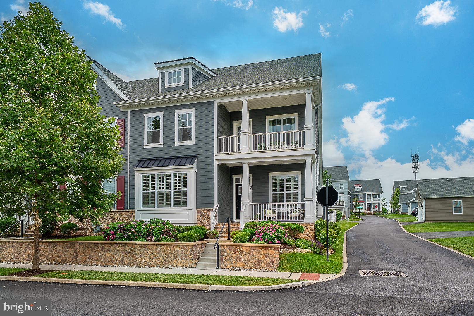Welcome to 239 Milton Drive — a distinguished end-unit luxury carriage home perfectly positioned on a premium lot within the highly coveted community of Spring Oak in Malvern. This exceptional Bonhill model seamlessly blends timeless design with modern elegance, offering 4 bedrooms, 3 full baths, and 1 half bath, all enhanced by meticulous upgrades, refined finishes, and an exquisite outdoor living space with professionally landscaped gardens and a stunning hardscape patio. A charming covered front porch overlooking tranquil open space sets the tone for the sophistication found throughout the home. Inside, the main level impresses with soaring 10’ ceilings, rich hardwood flooring, custom plantation shutters, detailed millwork, solid wood doors, upgraded hardware, and a bright, open-concept floor plan ideal for both everyday living and entertaining. The expansive Great Room features oversized windows with transoms, a 12’ box ceiling, and a gas fireplace — an inviting space with abundant natural light. The elegant Dining Room, accented by a designer chandelier, flows seamlessly into the chef’s Kitchen, outfitted with custom white cabinetry, Carrera marble countertops, stainless steel appliances including a 5-burner gas cooktop, wall oven, microwave, warming drawer, elegant range hood, and dual pantry closets. The main-level Primary Suite offers a peaceful retreat with spacious walk-in closets and a luxurious en-suite Bath featuring an oversized frameless glass shower, dual vanities with quartz countertops, and a private water closet. Additional highlights on the main level include a private Study with glass French doors and custom built-ins, a stylish Powder Room, and a well-appointed Laundry Room conveniently located off the Kitchen. Upstairs, a spacious Loft with hardwood flooring provides the perfect flex space for a Library, Playroom, or second Family Room. Three additional Bedrooms include one with a private balcony and one with an en-suite Bath. A well-appointed hall Bath with double vanities and a large walk-in storage closet completes the upper level. The expansive Lower Level presents an exceptional opportunity to create additional living space tailored to your needs — whether a 5th Bedroom, Home Gym, Media Room, or all of the above. Residents of Spring Oak enjoy maintenance-free living and access to resort-style amenities including a community pool, fitness center, and clubhouse. Located within the award-winning Great Valley School District and just minutes from top private schools, the Great Valley Corporate Center, PA Turnpike, Route 202, Paoli Train Station, and the shops and dining of Malvern and the Main Line — this is luxury living at its finest.