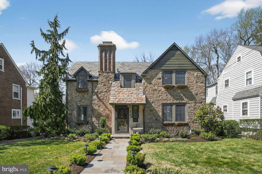 A flagstone walkway and lush landscaping lead to the classic stone exterior, where a prominent brick chimney serves as a distinguished architectural feature. Upon entering the foyer, archways create an elegant transition into the primary living spaces, showcasing the home's unique layout and generous room sizes. The main level features gorgeous hardwood floors that extend throughout the majority of the first and second levels. To one side of the foyer, a spacious living room offers a wood-burning fireplace and deep windowsills that add character to the light-filled space, with a seamless connection to the expansive sunroom. This sunroom is a true highlight of the home, featuring flagstone flooring and a vast footprint that makes it a favorite destination for both quiet daily living and large-scale entertaining. Doors from the sunroom leads directly to the patio, providing an excellent setup for guests. On the opposite side of the foyer, French doors lead to the formal dining room, which also features deep windowsills and refined woodwork. The flow continues through an archway into a kitchen designed with the chef of the family in mind. This impressive space features a vast amount of cabinetry, a custom range hood over a 6-burner gas range, and a convenient appliance garage to keep the counters clear. Inset ceilings and an abundance of recessed lighting illuminate the workspace, which includes a farmhouse sink positioned beneath a double window and beautiful granite counters. The kitchen is finished with a tile backsplash and offers ample space for casual family meals. A final archway leads into the huge family room, which is centered by a gas fireplace flanked by windows on each side. This room is finished with recessed lighting and features French doors that open to the outdoor entertaining area. Having both the sunroom and family room open to the patio is a great feature that allows for effortless flow during parties. A beautiful wood staircase leads to the second floor, which maintains a layout designed for maximum privacy. The primary bedroom is a generous size and features an updated bathroom with a tile stall shower. Two additional large bedrooms offer ample closet space, while a private fourth bedroom is tucked away down a few steps, providing a perfect retreat for guests. This level also includes an updated hall bathroom and continues the theme of hardwood flooring found throughout the home. The exterior is anchored by an enormous flagstone patio that overlooks a level yard, which backs up to quiet township property to provide a scenic and private backdrop. Andersen 400 series windows are good looking and efficient too!  Move-in ready and meticulously maintained, this residence stands out as a rare find that checks every box for a discerning buyer. This home is a 10!