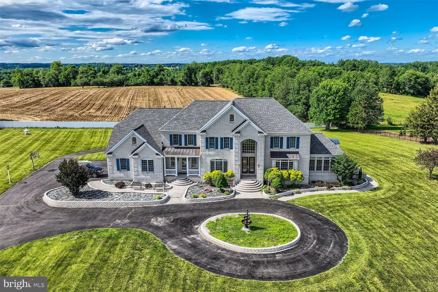 Glamorous custom built home offering over 10K square foot of living space situated on over three acres of land with a two-car detached garage plus an attached three-car garage. Drive up to the gated front yard, continue to the circular driveway boasting a custom fountain feature, and make your way to the door into your forever home. Step through the double door entry into this luxurious home boasting a two story foyer with marble flooring and a grand split staircase to the second floor with views of the living spaces below. This home features hardwood floors and custom woodwork throughout including crown molding, columns, and railings. Off the entry is a spectacular dining room with a tray ceiling and picture frame moldings, a butler's pantry leading to the kitchen, a large living room with tons of natural light and access to an adorable sun room surrounded by windows. A custom gourmet kitchen awaits you offering an abundance of cabinets with crown moldings, plenty of glistening granite countertops, a chef's slide in gas stove with oven below, custom covered vent hood, an additional wall oven, a built-in microwave, a double corner sink under a window with a view of the spectacular yard, and a grand island with seating and custom lighting. The open floor plan offers a large breakfast room and a grand family room with a two story view of the second floor landing and a gas fireplace. Completing the main floor are a half bath, mudroom with access to the three-car garage, and a spacious home office. On the second floor step through double doors into the Grand Primary Suite offering not one but three walk-in closets, a lovely sitting area or home office space, access to the laundry room, and an elegant ensuite boasting a jetted soaking tub, a large walk-in shower with bench seating, and his/hers vanities. There are three primary sized bedrooms all with private full baths and large closets. The lower level is filled with natural light and additional living space including a guest bedroom with a full bath, another home office with custom built-ins, a half bath, a large family room with a gas fireplace, a second kitchen/bar area, and french doors to a spacious covered patio in the amazing yard. From the main floor step out onto an enormous deck featuring an electric awning, and tiered steps leading to the abundance of green space, the oversized driveway, and the detached three-car garage. This home has so much more to offer new homeowners including 3 zone HVAC, and a new roof. Imagine living your best life in glamour and luxury, and still within close proximity to shopping, restaurants, and commuter routes.