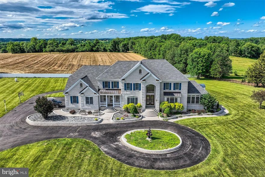 Glamorous custom built home offering over 10K square foot of living space situated on over three acres of land with a two-car detached garage plus an attached three-car garage.  Drive up to the gated front yard, continue to the circular driveway boasting a custom fountain feature, and make your way to the door into your forever home.  Step through the double door entry into this luxurious home boasting a two story foyer with marble flooring and a grand split staircase to the second floor with views of the living spaces below. This home features hardwood floors and custom woodwork throughout including crown molding, columns, and railings.  Off the entry is a spectacular dining room with a tray ceiling and picture frame moldings, a butler's pantry leading to the kitchen, a large living room with tons of natural light and access to an adorable sun room surrounded by windows. A custom gourmet kitchen awaits you offering an abundance of cabinets with crown moldings, plenty of glistening granite countertops, a chef's slide in gas stove with oven below, custom covered vent hood, an additional wall oven, a built-in microwave, a double corner sink under a window with a view of the spectacular yard, and a grand island with seating and custom lighting. The open floor plan offers a large breakfast room and a grand family room with a two story view of the second floor landing and a gas fireplace. Completing the main floor are a half bath, mudroom with access to the three-car garage, and a spacious home office.  On the second floor step through double doors into the Grand Primary Suite offering not one but three walk-in closets, a lovely sitting area or home office space, access to the laundry room, and an elegant ensuite boasting a jetted soaking tub, a large walk-in shower with bench seating, and his/hers vanities.  There are three primary sized bedrooms all with private full baths and large closets. The lower level is filled with natural light and additional living space including a guest bedroom with a full bath, another home office with custom built-ins, a half bath, a large family room with a gas fireplace, a second kitchen/bar area, and french doors to a spacious covered patio in the amazing yard.  From the main floor step out onto an enormous deck featuring an electric awning, and tiered steps leading to the abundance of green space, the oversized driveway, and the detached three-car garage.  This home has so much more to offer new homeowners including 3 zone HVAC, and a new roof.  Imagine living your best life in glamour and luxury, and still within close proximity to shopping, restaurants, and commuter routes.