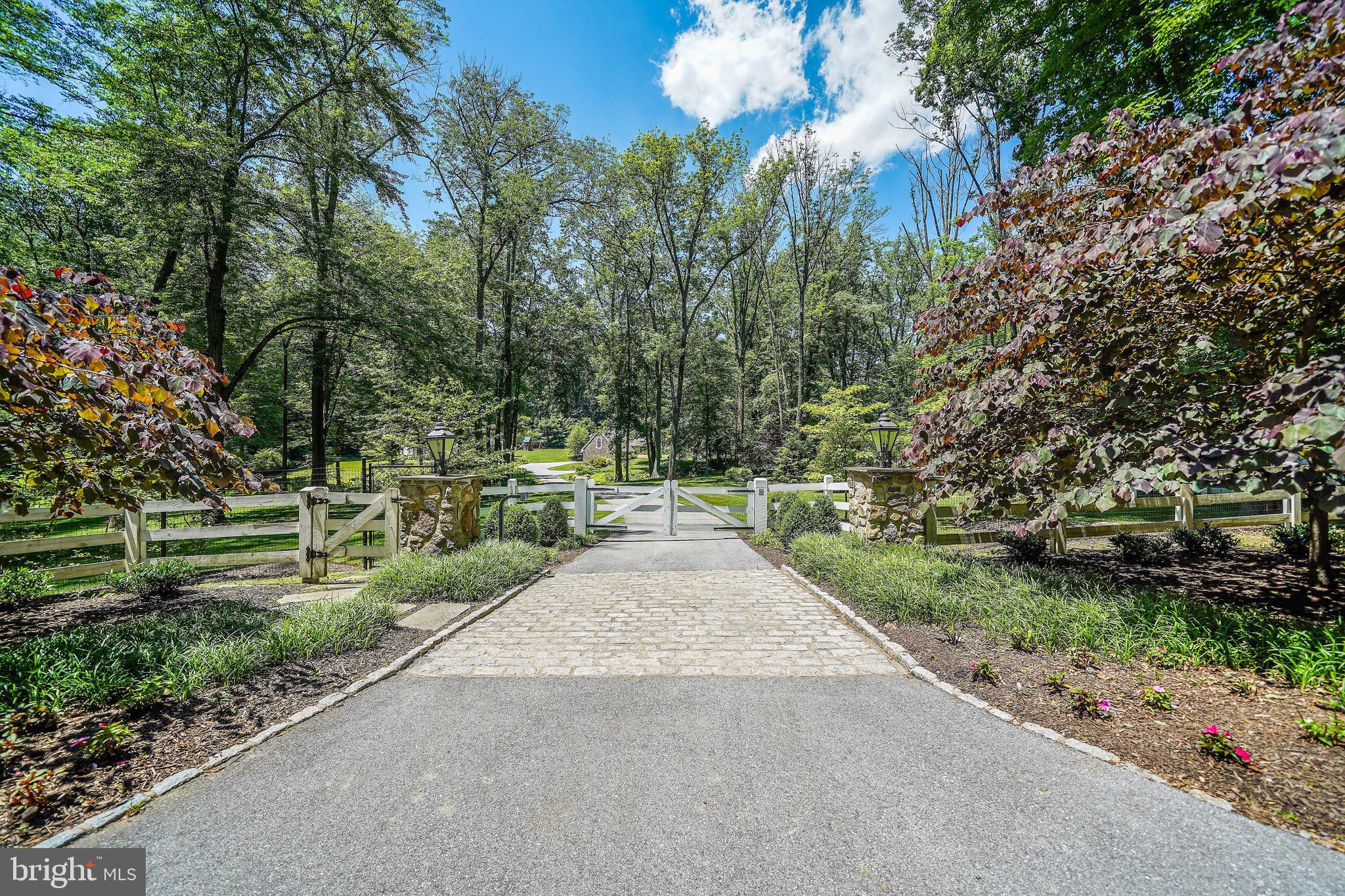 Elegance. Privacy. Comfort. Convenience. All four (and more) come together at 400 Dutton Mill Road, an exclusive estate nestled on 4.7 pristine acres in the prestigious Radnor Hunt community in Willistown. This secluded oasis features a 5,000+ -square-foot main house, ample outdoor space with landscaped gardens, winding walking trails, and a resort style pool, and stunning views of the surrounding countryside for the best in Main Line living.The gated entrance welcomes you up a stately driveway with the feeling of a country manor. But the highlight of this property is its abundance of meticulously cared for outdoor space and grounds that feature breathtaking scenes of the rolling countryside. The focal point of which is an impressive blue stone patio accentuated by the lush backdrop and linked to a nearby fire-pit with a relaxing seating area. Also, just steps away is a heated pool where you can make a splash or just refresh and unwind while taking in the panoramic backdrop of the pastoral property. Inside you'll find a light, airy atmosphere with no shortage of upgrades designed to impress and make your daily life a breeze. Meanwhile, one-of-a-kind design elements like custom mill work, luxury hardwood flooring, and artfully-crafted window moldings speak to a classic yet contemporary vibe. The chef-inspired kitchen features high-end appliances and granite counter tops, not to mention a propane fireplace in the eating area. From here you?ll find a spacious butler pantry that connects to an intimate dining room, French doors opening to a new patio, and a private, back staircase rise to your sleeping area. There?s also a new, over sized mudroom and storage area off the side entrance. The main family room welcomes you with warm wood accents, a stone, gas fireplace, and a wet bar and parlor area ideally suited for socializing over appetizers or after-dinner drinks. Sweeping windows bring in plenty of natural light throughout, as well as generous views of the native trees and vegetation. In addition to a bonus living area, tucked away you'll find a private corner office and a covered screened in porch where you can enjoy your morning coffee while checking emails or just taking in a good book. The second floor features four roomy bedrooms and three full baths. The primary bedroom offers two custom closets, a cozy propane fireplace, and a sizable tile bathroom with a steam shower, a soaking tub, and double sink. There is also a sitting room that could be converted into a fifth bedroom. In addition to three more bedrooms (including a princess suite), the upstairs has a large hall bath with double sink, and a laundry room accessible from both the hallway and primary bedroom. The finished basement is the perfect place for an extra playroom or theater room. In addition, above the detached (and spacious) three-car garage is a fully finished living area and full bath that could be used as a pool house, au pair suite, or gym. Ideally situated on the Main Line, this retreat is offers low taxes and is just minutes away from quaint town centers and desirable shopping and dining destinations, not to mention the Amtrak Train station and schools that are regularly ranked among the best in the Philadelphia area and the nation. Great Valley school district is one of top 10 public schools in the State of Pennsylvania. Large properties and estates go on the market every day. Rare jewels amid historic and untouched acreage do not. Come home to elegance, privacy, comfort, and convenience. Come home to 400 Dutton Mill Road.
