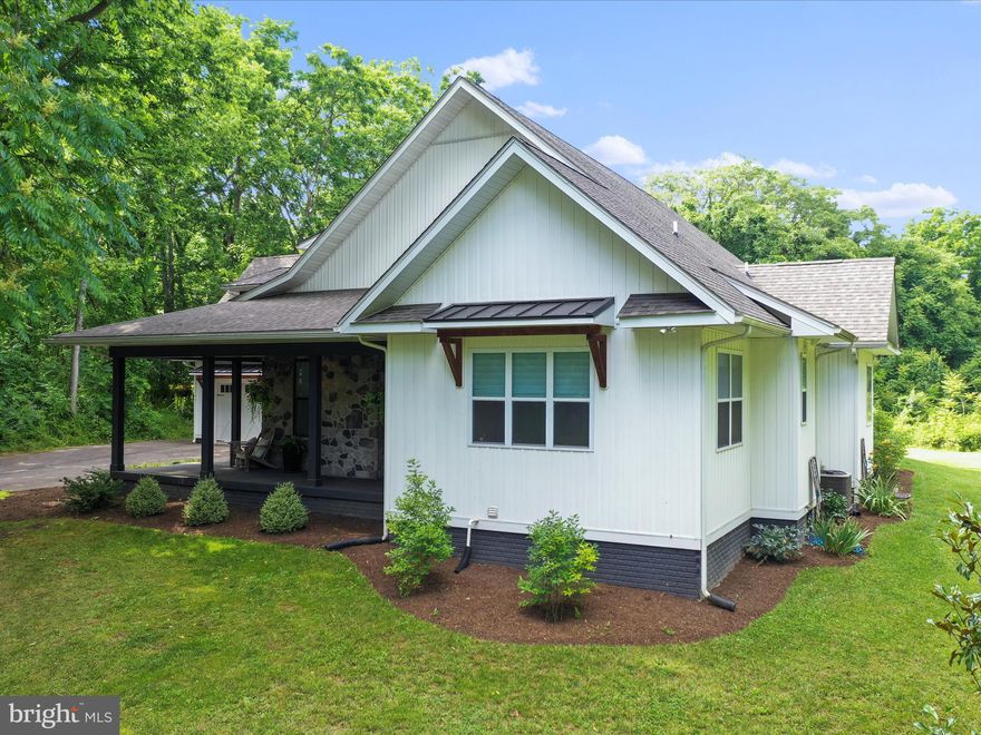 Discover the epitome of country charm fused with modern elegance in this artist’s oasis nestled on 2.5 serene, mostly wooded acres, just minutes from the vibrant heart of historic Shepherdstown, WV. This exquisite modern farmhouse-style home boasts 4 bedrooms, 4.5 bathrooms, and a 2 car garage offering an idyllic setting for both lively entertainment and tranquil relaxation. As you approach, the inviting front porch sets a welcoming tone with its stone-lined backdrop and chic black and wood accents—an idyllic spot to have your morning coffee amidst nature. Choose your entry through the classic front door or the convenient sliding doors that reveal a thoughtfully designed interior. Step inside to the practical mudroom area, complete with built-in shelves and hooks to organize your essentials. Adjacent, the laundry room with a handy sink and a spacious double-door pantry enhance your kitchen storage solutions. The heart of the home unfolds in the expansive open floorplan, seamlessly integrating the kitchen, dining, and living areas, complemented by a cozy nook—perfect for a piano or additional seating. The living area is anchored by a stunning stone gas fireplace, a warm focal point for gatherings. Across the room, the gourmet open kitchen awaits, featuring quartz countertops, a generous island with seating, full-size fridge and freezer, a range with a gas cooktop and electric double oven, and a dishwasher. The main level’s primary bedroom is a private sanctuary, with double doors leading to the back patio. Its en-suite bathroom is a luxurious retreat, offering dual vanities, a large soaking tub with a windowed backdrop, custom Hunter Douglas blinds, a walk-in closet, and a spacious shower. Two additional bedrooms share a connecting bathroom, while a convenient half bath completes this level. The newly finished basement is a versatile space, featuring a media room, an open area for a gym or entertainment, and an extra bedroom with a full bath and washer-dryer hookup. Ascend to the second level directly from the kitchen to discover a space with a full bath, adaptable as a 5th bedroom or additional living area. Outside, the back porch offers a large covered area and a wood-burning stone fireplace, perfect for cozying up on cool summer evenings. Custom Hunter Douglas blinds throughout the bedrooms provide privacy and light control. Property backs to 37-acre historic Springdale Farm. This home’s prime location affords easy access to downtown Shepherdstown, Shepherd University, the C & O Canal, and the Potomac River—ideal for enjoying local artisan shops, dining, and outdoor activities like hiking, tubing, and kayaking. For those commuting to DC, Maryland, or Northern Virginia, the MARC train stations are just 15 minutes away. This home is a rare find, ready to welcome its second owner. Don’t hesitate—schedule your viewing appointment TODAY and step into your dream of modern country living.
