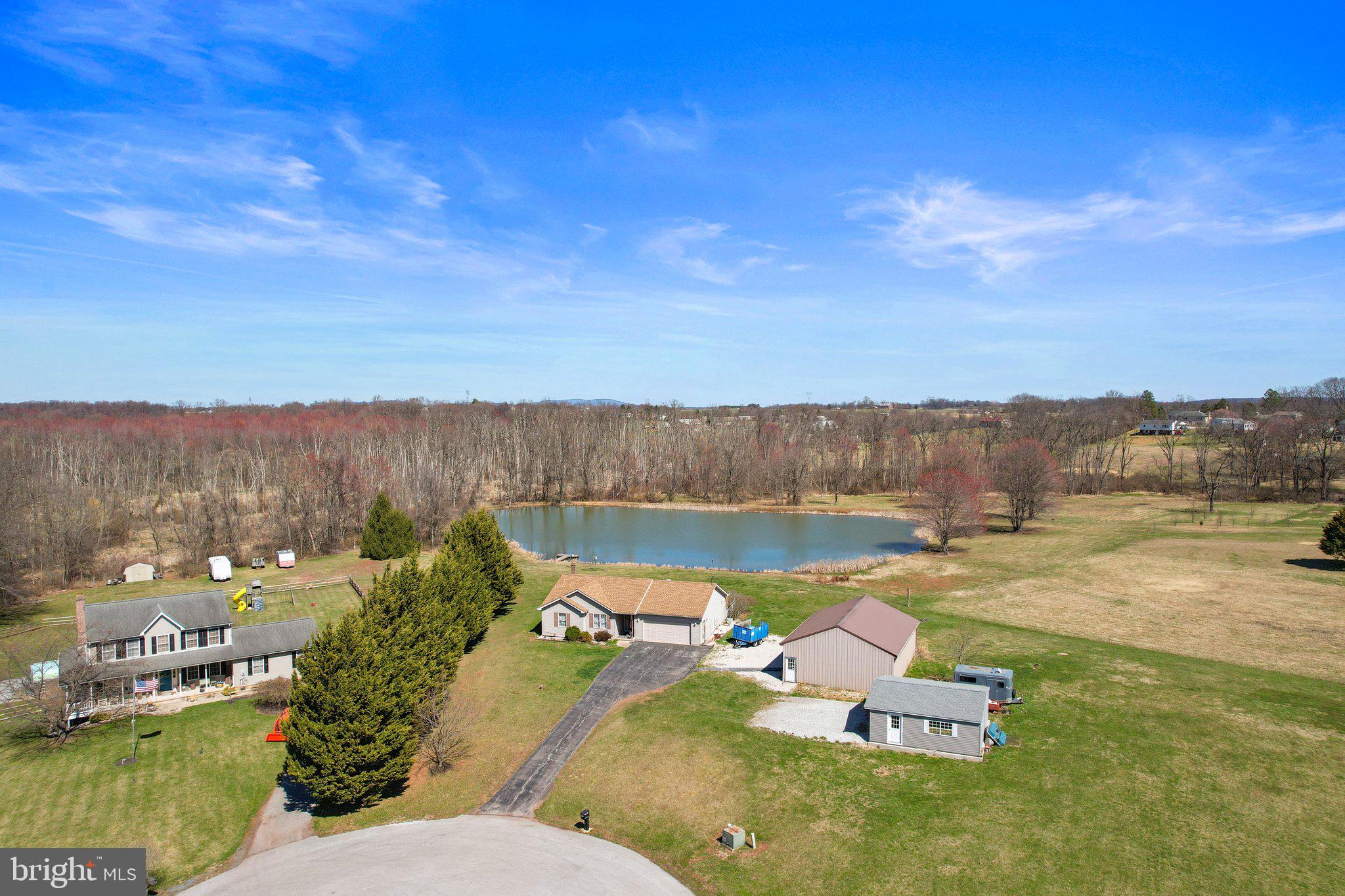 Discover the perfect blend of comfort and countryside serenity with this exceptional 3-bedroom, 2-bathroom rancher nestled on 16.63 acres in the sought-after Clean and Green program. Located on a quiet cul-de-sac just off PA 97/N Baltimore Pike, this property offers both privacy and convenience—only minutes from shopping and the historic Gettysburg Battlefields. Step inside to find a thoughtfully designed, one-level living space with an inviting atmosphere. The home boasts an attached two-car garage, providing easy access and ample storage. For those in need of additional workspace or storage, this property features a large detached garage and a spacious detached pole building with garage door access—ideal for hobbyists, car enthusiasts, or those with agricultural needs. Enjoy nature at its finest with a stunning approximate 2-acre pond, perfect for fishing, wildlife watching, or simply unwinding in a picturesque setting. Behind the pond, you'll find a beautiful wooded area with a small creek running through it, adding to the property's natural charm. This is a rare opportunity to own a versatile piece of land that offers a peaceful retreat while remaining conveniently close to town amenities. Don't miss your chance to experience this extraordinary property—schedule your private showing today!