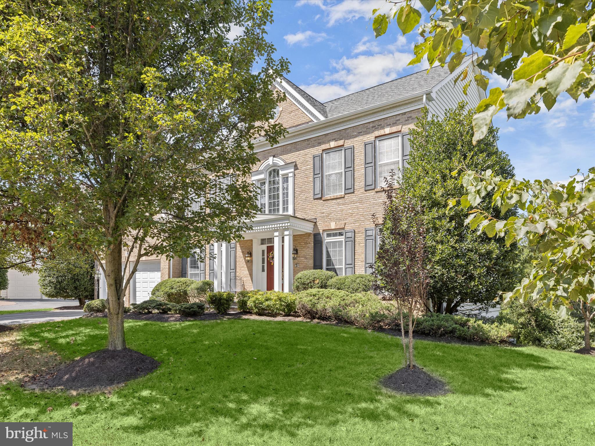 Introducing this remarkable five bedroom, four and a half bathroom home, perfectly situated on a 0.32-acre corner lot in the sought-after Montjoy neighborhood of Ellicott City. Nestled on a quiet cul-de-sac, it backs to woods with expansive rear and side yards for added privacy and space. Inside, a two-story foyer with curved staircase, hardwood floors, and abundant natural light set the tone, highlighting ornate trim and thoughtful details that continue throughout. The front living room offers a quiet retreat, while the formal dining room is generously sized for hosting gatherings. At the heart of the home, the expansive kitchen features granite countertops, tile backsplash, 42” cabinets with under-cabinet lighting, pantry, and a large center island with seating. Stainless steel appliances include recently upgraded double Café Wi-Fi wall ovens and a Bosch dishwasher, alongside a five-burner gas cooktop. A breakfast nook with desk station and second staircase is ideal for casual meals and opens to the two-story family room with a soaring cathedral ceiling and a gas fireplace. A half bathroom, laundry room with access to the two-car garage, and a private office enclosed by French doors round out the main level. Upstairs, the luxurious primary bedroom suite includes a tray ceiling, sitting area, and dual walk-in closets. The ensuite bathroom boasts a jetted soaking tub, walk-in shower, dual vanities, and private water closet. Down the hall, a second bedroom suite with its own private bathroom offers flexibility, while the third and fourth bedrooms share a connecting bathroom. Downstairs, the fully-finished walk-out lower level extends the living space, featuring a massive recreation room with a wet bar and space for everyone’s activities. This level also includes a fifth bedroom and an additional full bathroom, making it ideal for overnight guests or extended stays. An expansive storage room adds further convenience to the lower level. Outdoors, enjoy the peaceful yard that backs to preserved woods for a tranquil setting. Recent updates include a new roof, two HVAC systems with smart thermostats, water heater, upgraded wall ovens, dishwasher, and more.