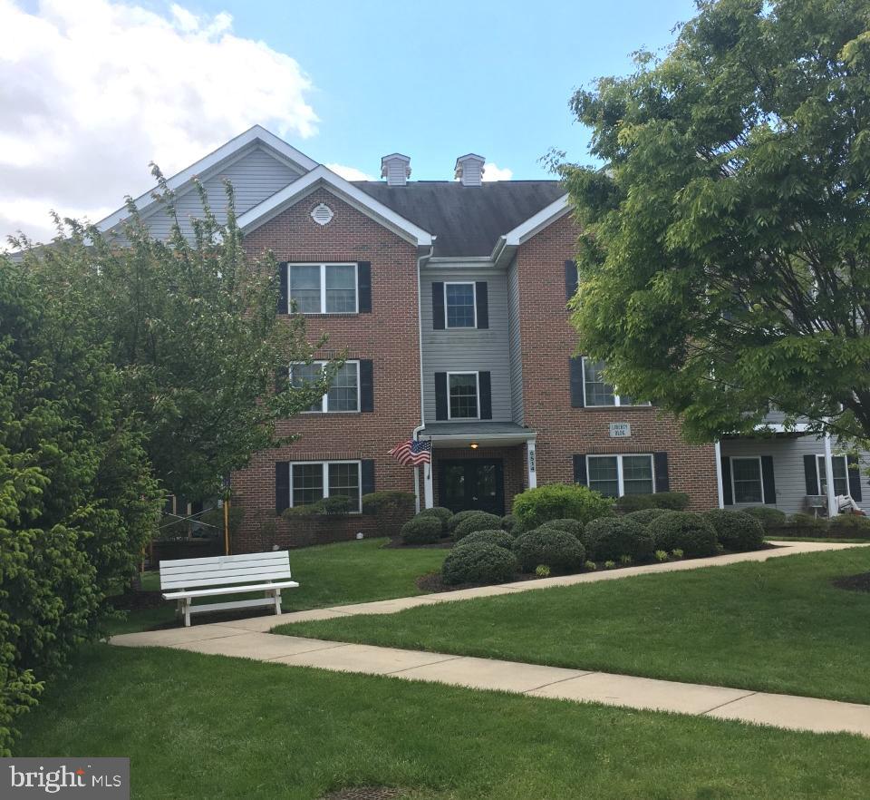 Welcome to this 2 Bedroom 2 Bath Condo with Garage and Elevator in the Desirable Nell's Acres 55+ Community!! This home is Freshly painted with new Carpet & Luxury Vinyl Wood floors and offering an open floor plan with a Spacious Living room, Built-in Bookshelves, a Gas Fire place & an exit to the private balcony with afternoon shade. The Kitchen offers plenty of space with a pass-thru view to the living room and the Dining area is just off the kitchen. The seller is offering a $2,500 credit towards appliances if desired. Also included is a Primary Bedroom w/Primary Bath & walk-in Shower, a Walk-in Closet with shelving along with a second bedroom or office and a first floor Laundry. There is a community room with activities & an exercise room to keep in shape. Don't miss your new Home in this sought after community.