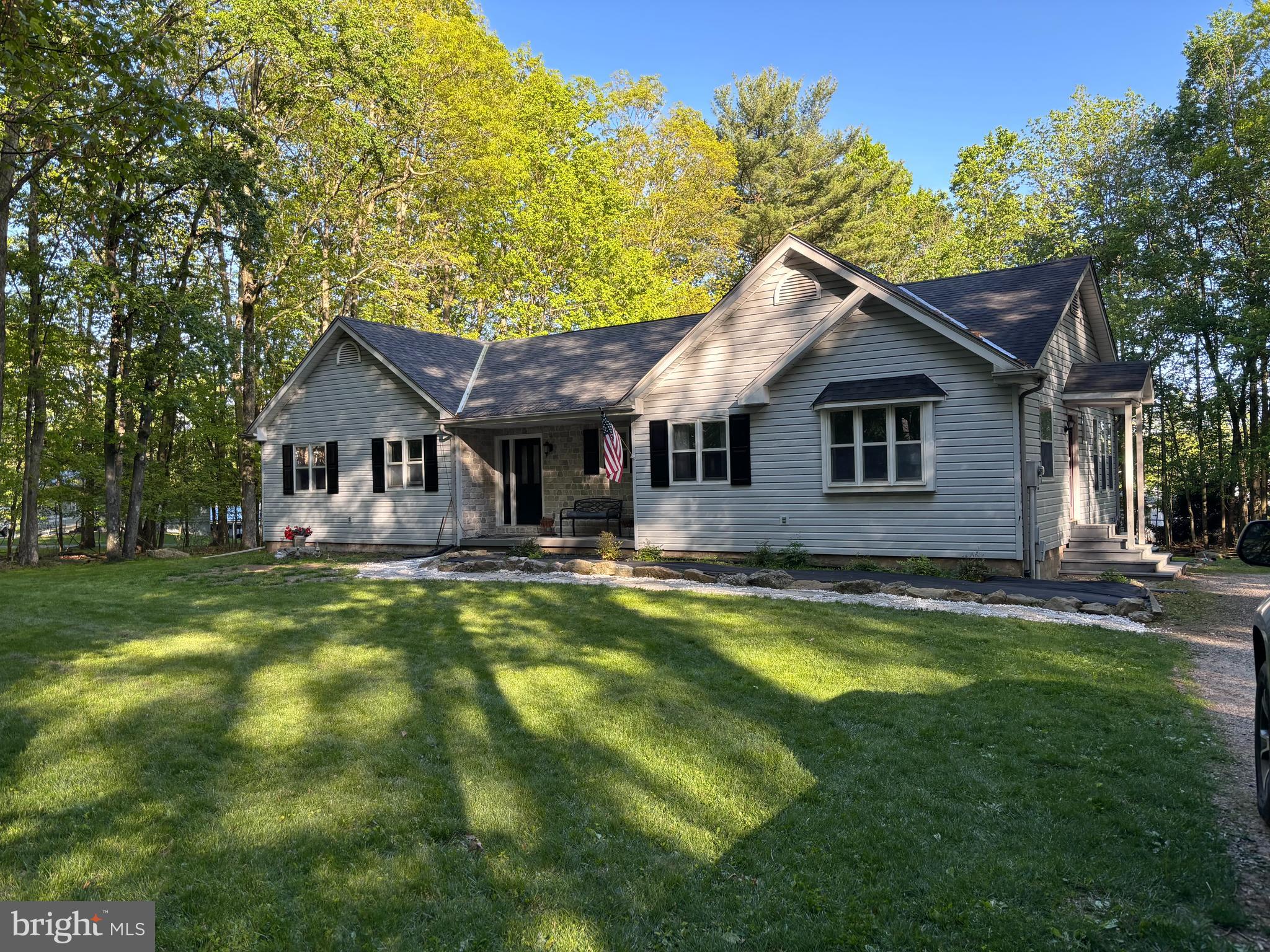 Welcome to this expansive 4-bedroom, 2.5-bath ranch-style home, privately set back from the road in a tranquil wooded setting. Built in 1991, this beautifully updated property offers the ideal blend of space, privacy, and modern comfort. Step inside to a show-stopping modern kitchen featuring cathedral ceilings, skylights, and a massive center island bar—perfect for gathering with family or entertaining guests. Brand-new flooring flows throughout the main living areas, enhancing the home’s open and inviting layout. The primary bedroom includes a private en suite bath, while the oversized fourth bedroom—complete with its own entrance—offers excellent flexibility for a guest suite, home office, or potential in-law setup. A bright and sunny sunroom provides the perfect space for working remotely, relaxing with a good book, or simply enjoying views of the surrounding trees. The large basement, with its own exterior entrance, presents a fantastic opportunity to create additional living quarters, a recreation space, or even a rental unit. With a timeless single-level design and a serene natural backdrop, this home offers both functionality and charm in a peaceful, private setting. Don’t miss the chance to make this rare and spacious property your own. Experience comfort, versatility, and privacy—all in one extraordinary home.