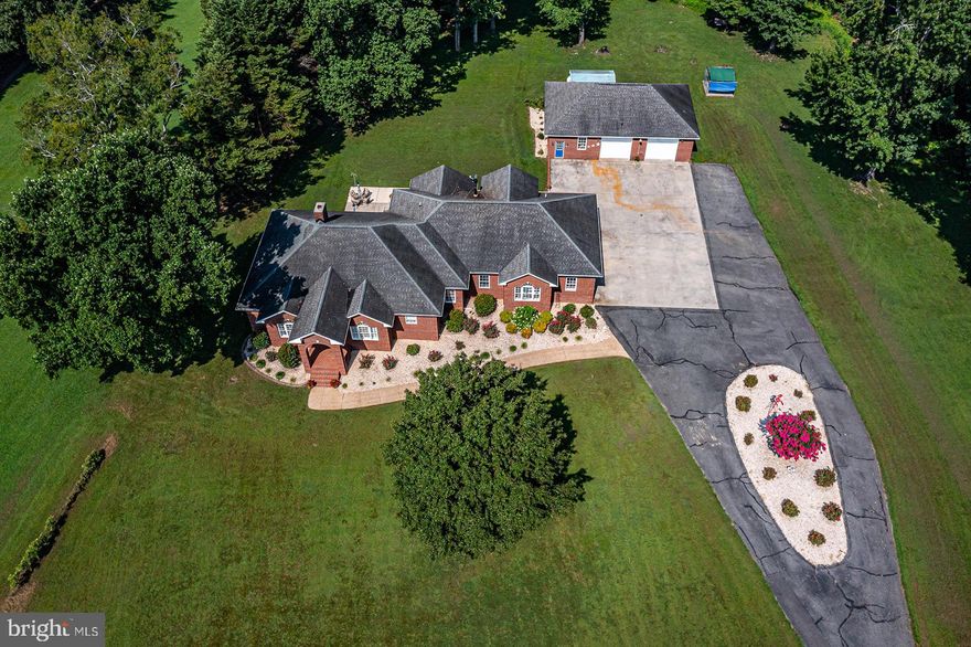 Space, space, and more space – both outdoors and in! This delightful 6.5AC property offers sweeping lawns, cooling woods, a detached brick garage with separate workshop, plenty of parking, and a stately brick 4BR / 3.5 bath home.  Enter to airy 10+ ceilings, hardwood and tile floors, central vacuum, and three main level bedrooms all in approx. 2,845 SF (larger than the County record).  The kitchen offers expansive counterspace, a breakfast nook with countertop bar, SS appliances and adjoins the dining room and living room. The primary suite has a separate shower, WC, jetted tub and dual sinks. A hall bath serves two additional main floor bedrooms.  Upstairs is a spacious, stand-alone bonus room for office, playroom, library, etc.  Stairs off the garage entry lead to a private upper bedroom suite.  Enjoy relaxing in the living room with the brick fireplace with gas logs, or step out onto the covered brick patio to enjoy the private rear yard.  Two heat pumps with 4 zones (both less than 5 years old) and backup oil heat keep you comfy all year around, helped by a climate-controlled crawlspace. No power? No worries; the generator will keep things going. Park your cars and toys in the attached 2 car garage (temperature moderated) AND the detached 2 car garage with running water and propane heater. (The workshop has a mini-split for full climate control).  Wander out the back into the woods to reach the serene wetlands with wildlife at the head of the creek. Minutes to the community dock and boat launch.  This property really needs to be seen to be appreciated! Bring your dreams and imagine the perfect country lifestyle at this gem of the Northern Neck!