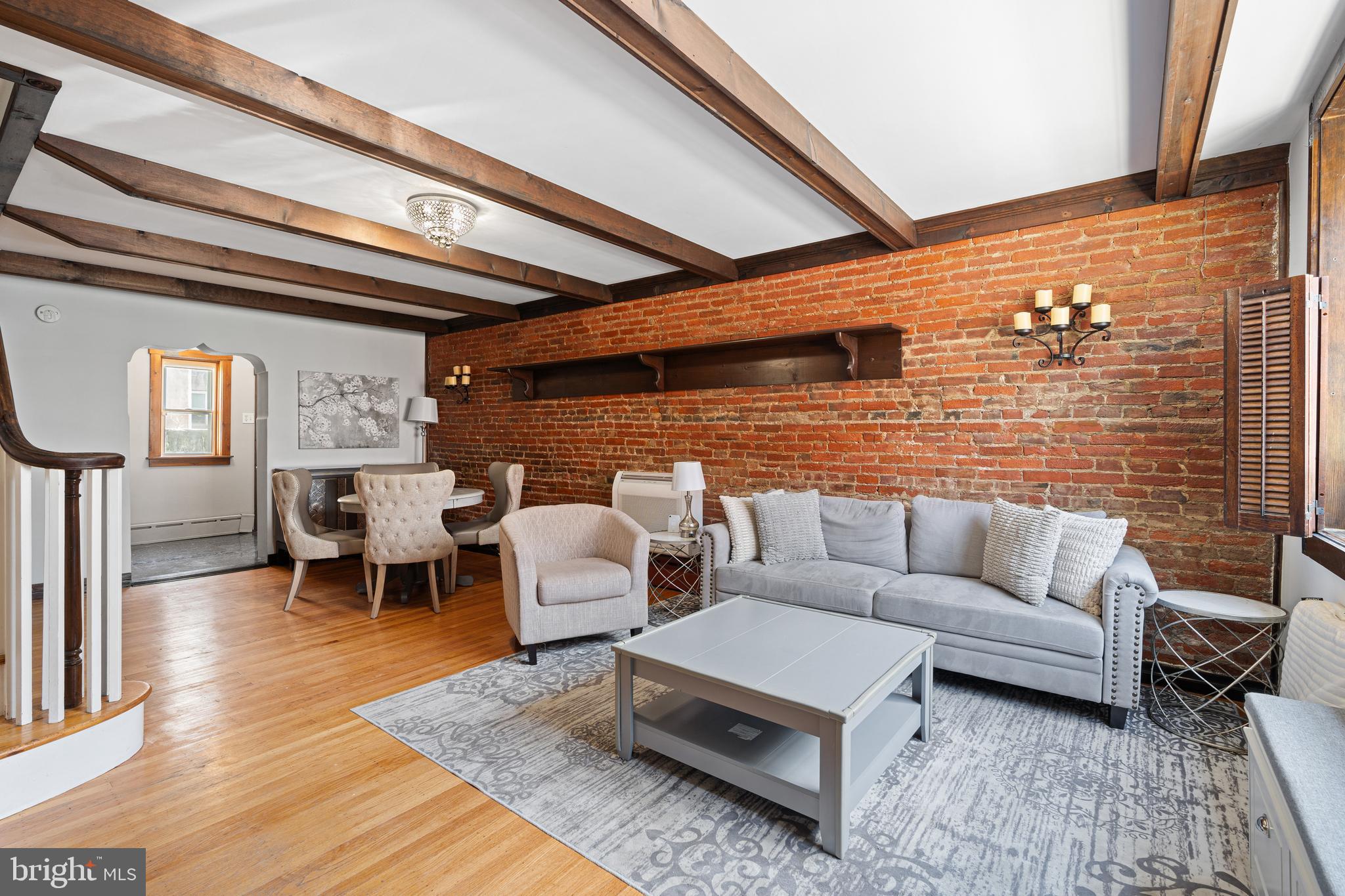 Tucked away on a quiet street, this sun-drenched 1,322 sq ft home is bursting with charm and character. The inviting first floor features exposed brick, rich hardwood floors, rustic wood beams, and a large front window that floods the space with natural light. The cozy living area flows seamlessly into a beautiful kitchen and adjoining breakfast room—perfect for entertaining, morning coffee, or casual meals. Step outside to your own private patio, ideal for grilling, gardening, or simply unwinding with a good book. Upstairs, you'll find two comfortable bedrooms, a full bath, and a versatile loft space—currently serving as the primary suite—complete with a powder room. Thoughtful details like skylights, a vintage clawfoot tub, and a French Godin wood/coal stove give the second floor a warm, peaceful feel. Additional storage is available in the basement, and the location can’t be beat—just minutes from SEPTA, the Italian Market, Passyunk’s top restaurants, Capitolo Park, and more. This home is truly one-of-a-kind. Come experience it for yourself!