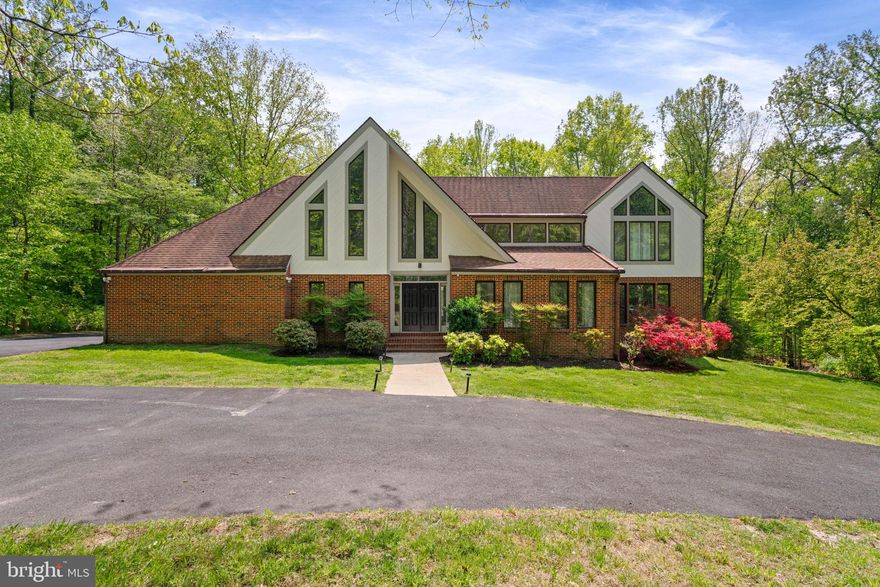 Exceptional custom home in Fairfax Station featuring 5 bedrooms and 4.5 bathrooms on 5 private acres, complete with a pool. Spanning close to 5000 square feet, this beautifully designed residence is nestled in the desirable Dominion Valley Hunt community just off Ox Road. An oversized three-car garage includes a Tesla Powerwall, whole-house backup power, and a rapid EV charging station.
Step into a dramatic two-story foyer with floor-to-ceiling windows that fill the home with natural light. The main level showcases hardwood floors, elegant formal living spaces, and a private office. A gourmet kitchen with stainless steel appliances overlooks the expansive yard and wooded surroundings, while a second-level deck provides serene views of the private pool.
Upstairs, the spacious owner’s suite features a private balcony, accompanied by three additional bedrooms and a full bath. The walkout basement offers even more living space, including an additional bedroom, den, and game room. With the convenience of dual laundry rooms and thoughtfully designed spaces throughout, this home is a standout choice for discerning buyers.