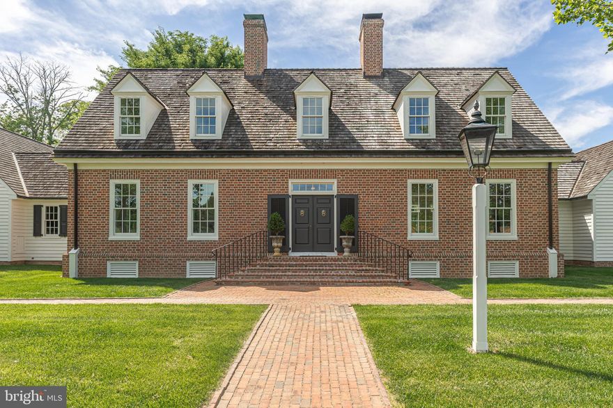 Nestled on a spectacular 15+ acre parcel just steps from the iconic Van Sandt Covered Bridge, with long-distance views of Bowman’s Tower, this Williamsburg-inspired brick estate—crafted by renowned local master builder Jarrett Vaughan—offers exceptional privacy and scenic vistas from nearly every room. This rare and manageable gentleman’s farm seamlessly blends refined living with a strong connection to its natural surroundings. A long, private drive leads to the stately residence, framed by manicured English-style gardens and mature landscaping. The interior showcases intricate moldings, gleaming oak hardwood floors, and timeless neutral finishes throughout.  The gracious first-floor primary suite features an elegant sitting area, dual walk-in closets, and a luxurious bath with jetted tub, along with serene rear views overlooking Pidcock Creek. The gourmet kitchen and adjacent breakfast room are equipped with Wolf and Sub-Zero appliances, granite countertops, a large center island with farmhouse sink, abundant cabinetry, and a cozy fireplace. French doors open to a covered patio and expansive rear grounds. A butler’s pantry and first-floor laundry complete this well-designed space.  Additional main-level highlights include a formal dining room with built-in corner cabinets and a grand family room centered around an impressive fireplace.  Upstairs, two spacious bedrooms each offer walk-in closets and en-suite baths, along with a versatile flex room that can be used as 4th bedroom or lounge, and a large balcony overlooking the gardens and fountain—easily adaptable as a potential fourth bedroom.  The finished lower level provides an ideal entertaining space with a granite-topped service bar, large cedar closet, workout room, and ample finished and unfinished storage, with direct access to the three-car garage.  Complementing the residence is a beautifully appointed horse barn featuring three generous stalls, wash stall, tack room, feed and equipment storage, and space for three to four large vehicles. Three fenced paddocks include one with direct stall access. The well-constructed barn also offers flexibility for alternative uses such as a pool house, workshop, or guest quarters.  Ideally located on one of the most coveted roads in eastern Solebury Township, equidistant to New Hope and Newtown Borough, with convenient access to Route 202, I-295, and regional rail. This exceptional property offers a rare combination of sophisticated estate living and equestrian amenities—a truly one-of-a-kind opportunity.