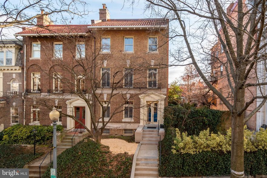 Sited in the prestigious Kalorama Triangle neighborhood of Northwest DC, 1828 Wyoming Ave NW is a quintessential 1912 Federal semi-detached Townhouse offering a beautiful blend of classic architecture, modern amenities and unique, yet timeless, design. It sits high on Wyoming Avenue with incredible southern views of the Washington Monument and Capitol Building. Meticulously maintained with updated baths, the 5 Bedroom, 4 Full Bathroom, 2 Half Bathroom residence showcases impeccable millwork, gleaming hardwood flooring and light-filled living spaces across 3 finished levels and 6,704 total square feet. 
Classical charm meets modern luxury as high ceilings and beautifully crafted crown moldings welcome you to the Main Level’s formal living spaces. Natural light floods the generous Living Room through oversized transom windows, highlighting the wood-burning fireplace’s millwork mantel. Large entryways lined with decorative trim lead to a spacious Dining Room, complete with modern wainscoting detail, the gracious Eat-In Kitchen, and Laundry Room. An expansive and fully fenced rear Terrace is accessible from the Kitchen and offers an ideal place for large scale gatherings and entertaining. 
A grand staircase ascends to the Upper Level’s informal Family Room showcasing stunning built-ins, oversized windows and a large fireplace with brick surround. A perfectly appointed balcony overlooking an enviable Northwest DC cityscape is accessible from one of the Upper Level’s two Bedrooms. Perched on the Top Level, the sprawling Primary Suite boasts an organized Walk-In Closet and a spa-like en-suite Bath complete with dual vanities, soaking tub and walk-in slate shower, creating a luxurious oasis within the home. Two additional Bedrooms, each offering updated en-suite Bathrooms, are located on the Top Floor and round out the guest amenities this townhome offers. The unfinished, walkout Lower Level provides ample storage space or the perfect setting for a Recreation Room, Exercise Room, and more! An attached 2-Car Garage is accessible from the Lower Level, a rare offering in one of DC’s most urban neighborhoods.