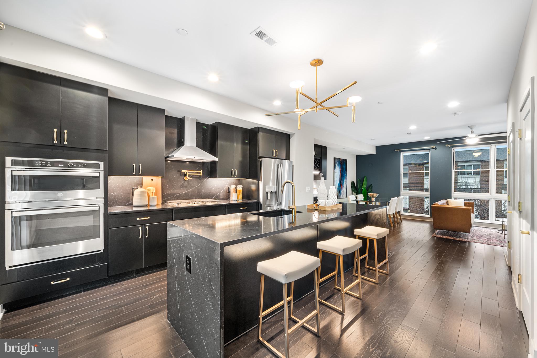 **UPGRADED FEATURES INCLUDED: POWDER ROOM AND PANTRY ON THE MAIN LEVEL, FULL BEVERAGE CENTER, QUARTZ BACKSPLASH, POT FILLER, WASHER/DRYER.** Presenting a rare opportunity to purchase one of these properties LIKE-NEW without the first year woes of new construction. The Residences at Park Avenue is a community of stylish, 21.5’ ultra wide homes located just steps from Fairmount and Center City. After parking in your covered, 2-car carport, enter into the first floor. Here you’ll find a bright bedroom and a full bath, as well as large open space, perfect for an office or sitting area. Heading upstairs you will find the open concept floor plan that allows kitchen and living areas to blend seamlessly together. This kitchen is a stunning custom combination of stylish black cabinets with black quartz counters that were upgraded to seamlessly carry up as the backsplash. Gold hardware, including the upgraded pot-filler, is the perfect extra touch. Your dining area includes the upgraded beverage center, featuring a wine rack, a beverage fridge, and extra storage. For added convenience, the home includes the upgraded addition of a powder room on this main level, as well as a sizable pantry, making the most of the space. A large deck off of the kitchen area furthers extends the space, adding significant square footage that is perfect for entertaining or meals outside. Up on the third floor, you’ll find the primary bedroom with an extremely stylish en-suite bathroom and large closet. You’ll love the spa-like features with finishes thoughtfully selected by professional designer, including gold fixtures and a frameless glass shower. Rounding out this floor is another large bedroom and a hall bath. The fourth level is your outdoor oasis– a 400+ sq ft deck with views of Center City and Northern Liberties. Lastly, retreat to your finished basement space with luxury vinyl floors and 9ft ceilings. This additional 711 sqft is perfect for your den, a gym, playroom and more! Extremely convenient access to the Broad Street Line will get you to the stadiums in just minutes, as well as the best bars and restaurants downtown. The proximity of Aldi allows you to pop in for anything you need without barely having to leave the development. Just a few minutes walk will get you to Santucci’s, Osteria, the Divine Lorraine offerings, the MET, Fairmount Ave, and so much more. With about 9 years left on the FULL tax abatement, this is the perfect scenario. Do not miss out!