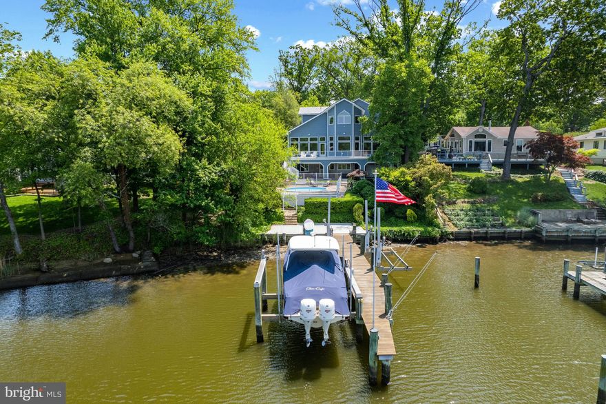 Severna Park Waterfront Gem – A Boater’s Deep-Water Paradise: Stunning waterfront, contemporary, custom-built home in Severna Park with panoramic views, deep-water private dock, and pool in the sought-after Manhattan Beach community.  This unique property was completely rebuilt from top to bottom in 2013.  The owners, both engineers, wanted an energy efficient and green residence that would meet higher standards than conventional construction.  Their goal was to achieve a solid, healthier, more resource-efficient and cost-effective waterfront home.  Architect Teresa Todd and builder Perry Bonner from Delta Building Corp. captured their dream.  
This 6-bedroom, 4-bathroom, 5,339 square foot gem boasts water views from almost every area.  The .25-acre property is nestled on Cypress Creek that feeds into the Magothy River, a tidal sub-estuary of the Chesapeake Bay.  The deep water (5ft MLW) 55 feet private dock with 3-boat lifts and mooring whips are perfect for the boating enthusiast.  Water activities at your footstep include power boating, sailing, kayaking, paddle boarding, canoeing, rafting, swimming, fishing, crabbing and endless others. This is also a wonderful home for entertaining; open-floor layout, outside deck with water views, pool with Tiki Bar, and an additional “catering” kitchen with direct access to patio.  This is the perfect waterfront lifestyle.
This modern home has three levels.  When you enter the elegant foyer there is a beautiful marble tile with geometric inlay, high ceilings and immediate water views.  The main level has an open-layout floor plan and is all with hardwood floors.  Also, a bedroom with an ensuite bathroom and bay windows, a hard find as most properties do not have bedrooms on a main level.  The kitchen, living and dining areas have floor to ceiling Anderson windows so you can enjoy the breathtaking water views.  The state-of-the-art kitchen, which is between the open living and dining areas, creates a symmetry and balance between those two spaces.  The gourmet kitchen which is equipped with a Thermador 48” six gas burner/griddle cooktop among other stainless-steel appliances, has a mosaic backsplash, a large island all with granite countertops, and a breakfast bar with pendant lighting and seating for at least 6-people.  Behind the breakfast bar there is an alcove with bay windows and a stunning wood floor medallion compass rose inlay.  This medallion creates a focal point that gives flow and continuity between the living and dining rooms.  The living room has a gas fireplace and direct access to the outdoor, low maintenance, aluminum deck.  The dining room also has access to the outside deck and butler pantry.  You can also enter the main level directly through the oversized 2-car garage with door access into the tile floor mud room.
The upper level, mostly with hardwood floors, features a primary bedroom with ensuite spa-like bathroom, 2-bedrooms with jack and Jill bathroom and a large laundry room with utility/mop sink and under counter storage cabinets.  The stunning primary suite has water views, vaulted ceilings, and ample walk-in-closet with island.  The lower level consists of a large family/recreation room with a fully equipped kitchen.  Through this area you can enter the patio that has electric heaters and access to the pool and dock.  Also, 2 additional bedrooms which are currently used as home office and fitness room.  Other rooms include fully equipped workshop, “water toys” storage with roll-up door, utility, and a wine cellar.  This Severna Park waterfront gem is part of the desirable Manhattan Beach community which has access to several beaches, a boat ramp, and a clubhouse. Blue Ribbon Schools and the Baltimore-Annapolis bike trail, restaurants, shopping, entertainment, and bus transportations.  This Boater’s Deep-Water Paradise is a short distance to Annapolis (18-miles), the Eastern Shore (25-miles), Baltimore (39-miles) and Washington DC (60 miles).