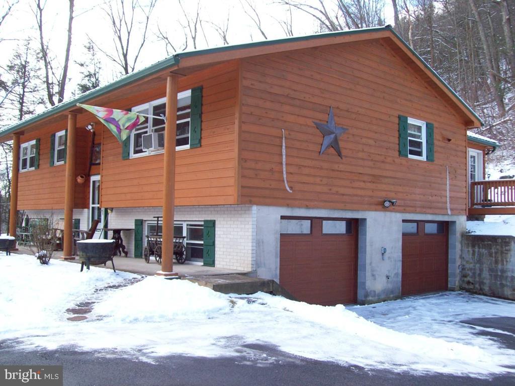 Beautiful home w/1.96 acres across from State Game Land.Just about everything has been replaced since 2010.Custom oak kitchen w/small island,solid oak doors,a tasteful mix of wood,laminate,vinyl & ceramic flooring throughout. Cedar siding & metal roof.Woodstove heats entire house.Enjoy the comfort of the heated sunroom all year round, also added in 2010. Integral 2 car garage, plus 2 outbuildings. Full bath on 1st floor, half bath in basement.