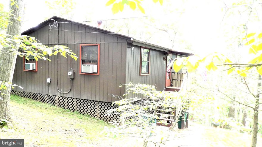 Excellent opportunity to own a Cabin in the woods, cozy, private, and in excellent condition. Open floor plan including cathedral ceilings, both an open and screened-in deck. Community Lake, Ballfield, and Pavilion. The lot backs up to the Sleepy Creek Wildlife Management Area, nearly 23,000 acres, and a 205-acre lake. You can walk just behind the cabin and enjoy all the hunting, trapping, fishing, hiking, and camping you like. Check it out by searching "Sleepy Creek Wildlife Management Area online.-  This is a perfect property for someone looking for some outdoor adventures. Most furniture and lawn equipment conveys. A must-see. Schedule your showing now so you don't miss out.