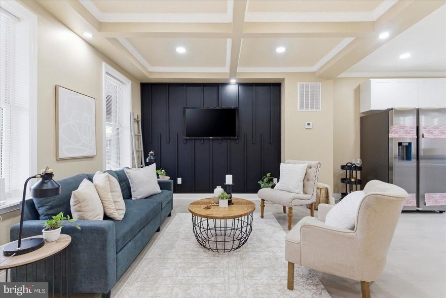 An unbelievable transformation has taken place behind the door of this 3BR/3BA Townhome which is located in the quiet neighborhood of Mondawmin.  Make your way to the covered front porch, which features a wood beadboard ceiling and open the door into your forever home. You will not believe your eyes when you open the door and step inside to a glamorous main floor boasting high custom tray ceilings, crown molding, recessed lighting, luxury flooring, and the open floor plan homeowners are seeking.  The main living space features a large living room with a custom feature wall, a glamorous kitchen, and a dining area.  The kitchen boasts plenty of cabinets, stainless steel appliances, granite countertops with a complementing tiled backsplash, and a stainless sink set into an island featuring a waterfall edge, breakfast seating for three or more, and glamorous pendant lights.  Tucked behind the kitchen is the convenience of main floor laundry. On the second floor you will find a sizable secondary bedroom with a beautifully tiled full bath, and a primary suite.  The primary bedroom features a large closet, a private full bath with a tiled walk-in shower, and French doors leading to a private covered deck overlooking the yard. The lower level contains the third bedroom, a full bath with a walk-in shower, a spacious family room, storage, and a walk-out to the fenced yard.  From the main floor step outside to a fenced yard filled with possibilities. This home is stunning, ideal for any new homeowner and is located near shopping, restaurants, and commuter routes.