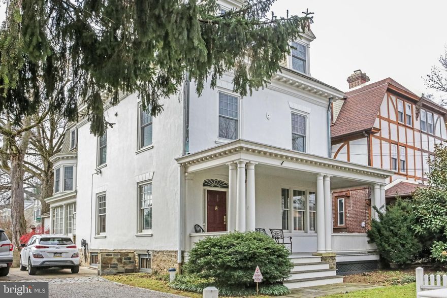 Here is an opportunity to live within the walls of history, surrounded by contemporary style, and embedded with 21st-century amenities. Come see this extraordinary Germantown property and experience the space, the charm, the character, and the serenity that you have longed for in a Philadelphia home. This 1857 home, originally built for John Wister, rests on an extraordinary 60 x 150' lot that allows for the home to be set well back from the street, a large rear bricked patio, a spacious side yard, a parking area for up to 4 cars, and all directly across from beautiful 8 acre Vernon Park. Enter this property through a lovely front porch, beyond the fanlight door surround, into an open entrance hall featuring an early 20th-century pendant light, clear finished oak floors that run throughout the living areas, and the original corner fireplace. To the right is a beautiful staircase backed by leaded glass windows. A cushioned window seat looks out onto the front porch. Through the entrance hall is a spacious living room highlighted by original window and door moldings. There are windows on both sides of the living room and also a door to the sunporch. Through a wide opening lies the dining room, beautifully lit by south-facing French doors that open to the sunroom. An elegant crown molding runs the perimeter of the dining room. The sun-drenched kitchen anchors the first floor. It has extensive cabinetry, up-market appliances, plenty of granite counter space, and a large island for meals and gatherings. The kitchen floors are original yellow pine painted in a historical pattern and the ceiling is tongue and groove pine. A beautiful archway opens to a back staircase to the 2nd floor. To the rear of the kitchen is a large mudroom with laundry, a large original utility sink, a half bathroom, and additional storage. Beyond the mudroom is the brick patio backed by a massive, well-maintained, white ash tree providing afternoon shade in the warmer months. The second floor features 3 bedrooms. The large primary bedroom is in the front of the house. It offers windows on two sides, double closets with beveled mirror doors, and plenty of space for a king bed as well as a seating area. The adjacent bathroom features a double vanity and a spacious, frameless glass shower. Next to the primary bath is a hall bath with an exceptional vitreous ceramic freestanding tub with shower surround, and a nickel and marble early 20th century style sink. The middle bedroom has two large south-facing windows and good closet space. The rear bedroom is quite large and features a 3 paneled, south-facing, bay window flanked by built-in bookshelves, and has a west-facing window that overlooks the patio. In the center of this floor is the skylighted staircase to the third floor which has 4 additional bedrooms, and a lovely hall bath with wallpaper and wainscoting. The basement is large, very dry, and perfectly suitable for storage. It also houses some extraordinary mechanical systems including geothermal cooling, a sophisticated hot water heating system, and a 200' deep natural well bringing filtered water into the kitchen, and natural water for all of your gardening and landscaping. Located just a couple of blocks from GFS and Greene Street Friends schools, there is more to be shared about this exceptional property than can be appropriately expressed here. If you are serious about starting the next phase of your life in an incredibly well-updated and wonderfully well-maintained historic home, reach out for an appointment today.