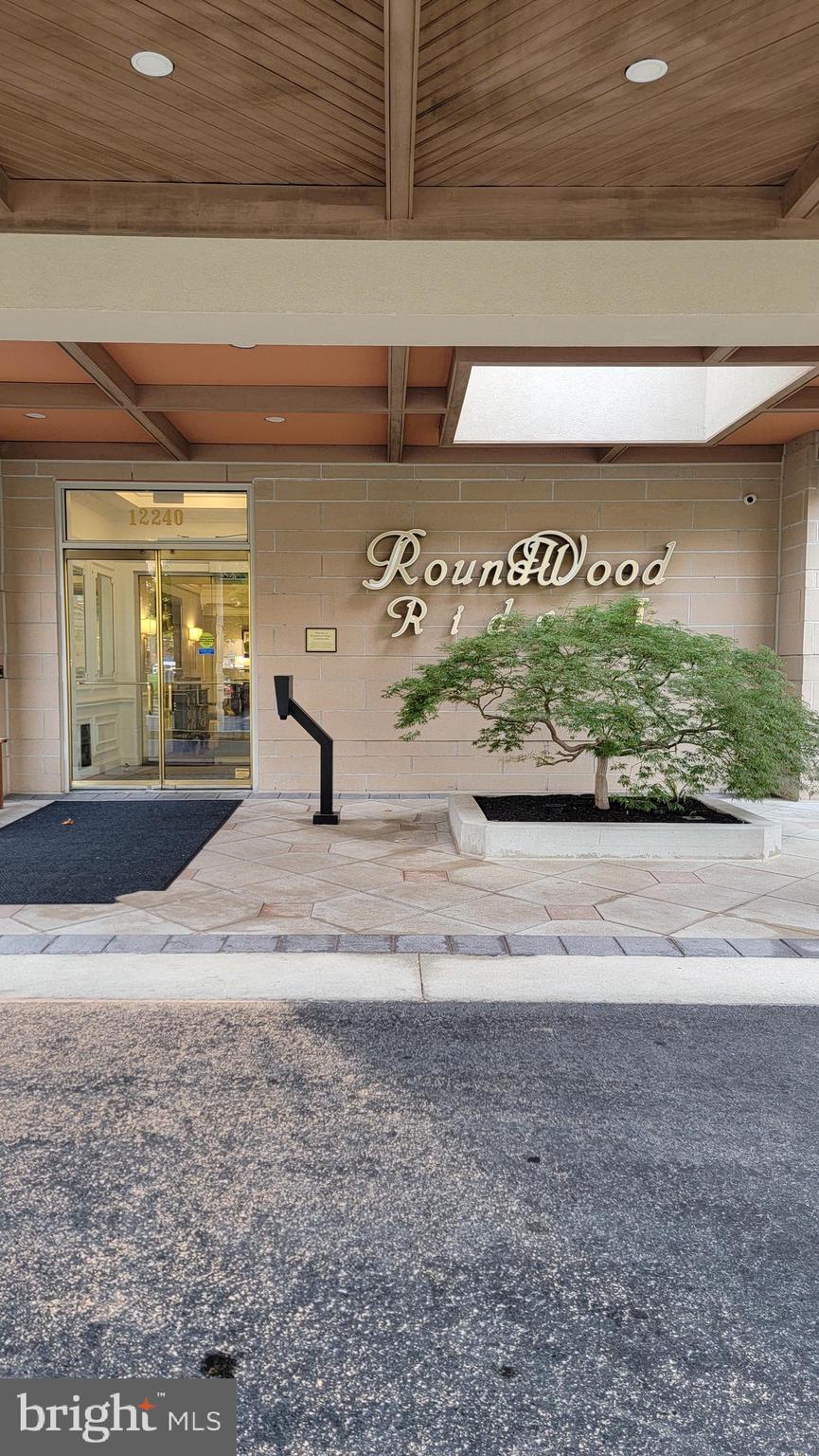 Experience sophisticated living in this pristinely maintained 2 BR, 2 BA residence with a versatile den/office and assigned garage parking, located in the prestigious Roundwood Ridge community of Mays Chapel North. This spacious residence offers 1,697 sq. ft. of thoughtfully designed living space on a desirable high floor. Upon entry, an open foyer with gleaming hardwood floors flows into a light filled living room with a large window and crown molding and the open dining room with its coffered ceiling and additional trim work. A large eat-in kitchen features gas fireplace, central island, under-cabinet lighting, plenty of cabinet space and direct access to a private balcony with peaceful, unobstructed views. Primary bedroom includes a large window, generous walk-in closet and ensuite bathroom complete with double sink, linen closet and a walk-in shower. The secondary bedroom is conveniently located across from the hall bath. The additional den offers an ideal space for a home office, media room or guest room. Additional features include brand new neutral carpet in the bedrooms and den, new hot water heater installed in 2024, a spacious laundry room equipped with newer washer/dryer, a utility sink, glare resistant tinted windows and ample storage shelving. You'll also find two additional storage closets located in your hallway. This beautifully maintained and secure building offers numerous amenities including newly updated lobbies and hallways, two elevators, community room for social gatherings and a climate controlled storage unit conveniently located right down the hall. Walking distance to Grauls Market, shops, restaurants, Walgreens and Starbucks while having convenient access to I-83, I-695, Hunt Valley, Towson and downtown Baltimore. Enjoy the convenient, maintenance-free lifestyle of condo living. A must see!